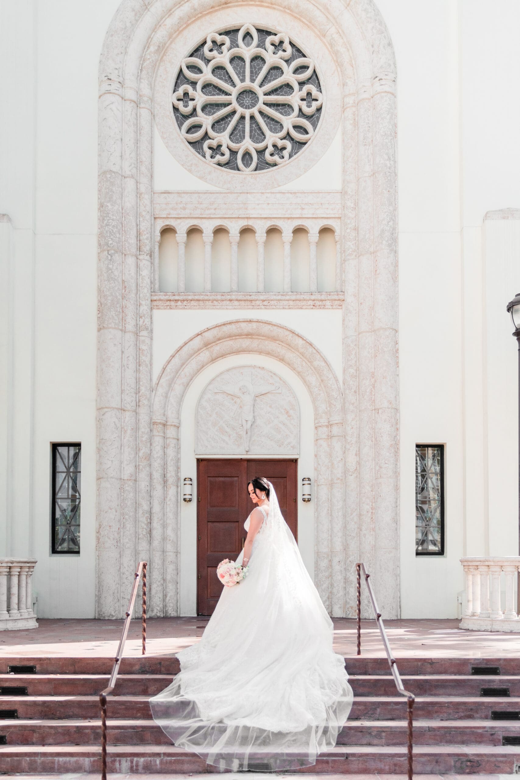 Jessica standing alone in front of St. James Cathedral, her dress flowing gracefully down the steps.