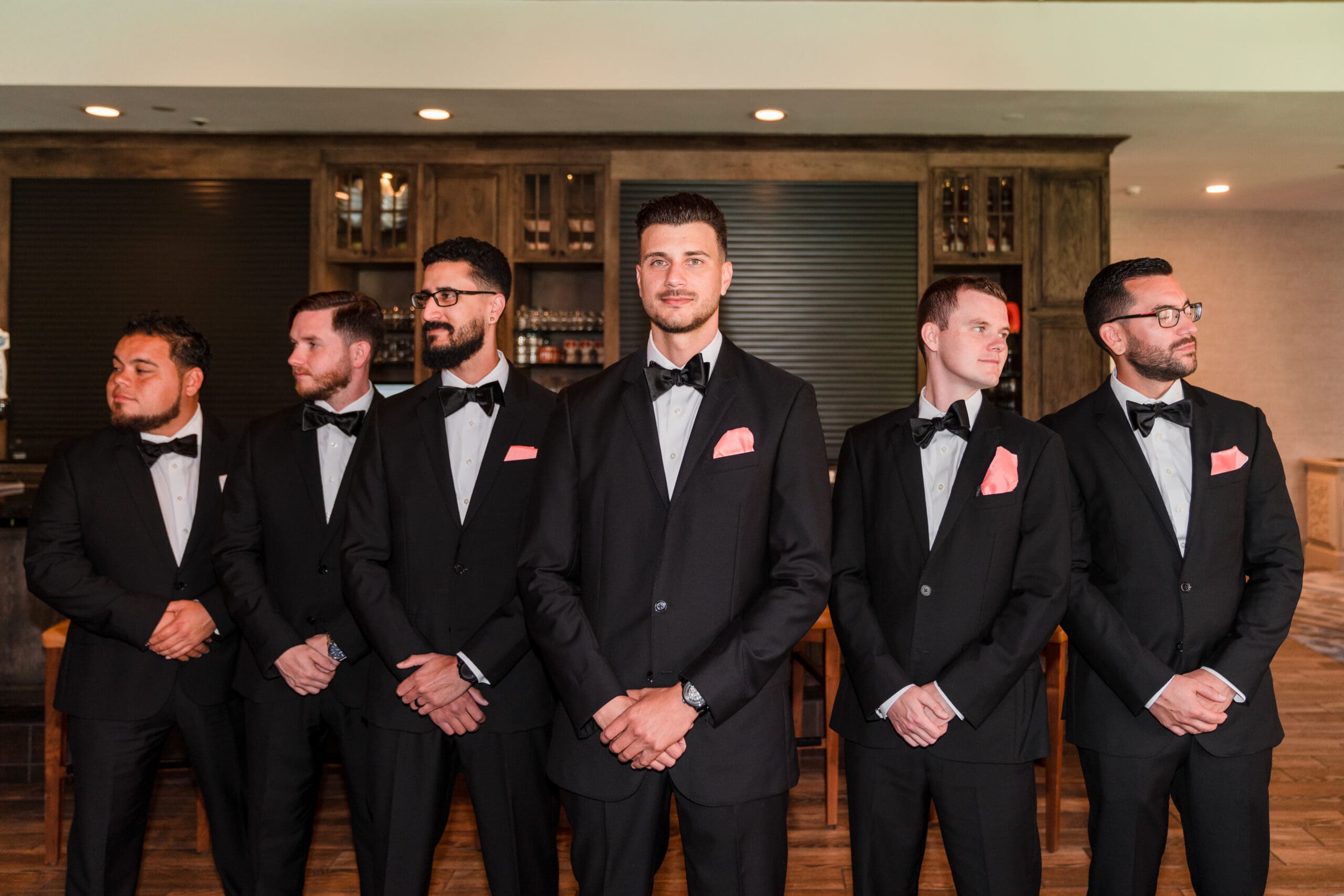 Javier and his five groomsmen posing for an epic picture, forming a V-shape with Javier at the center looking at the camera and the others looking in the distance.