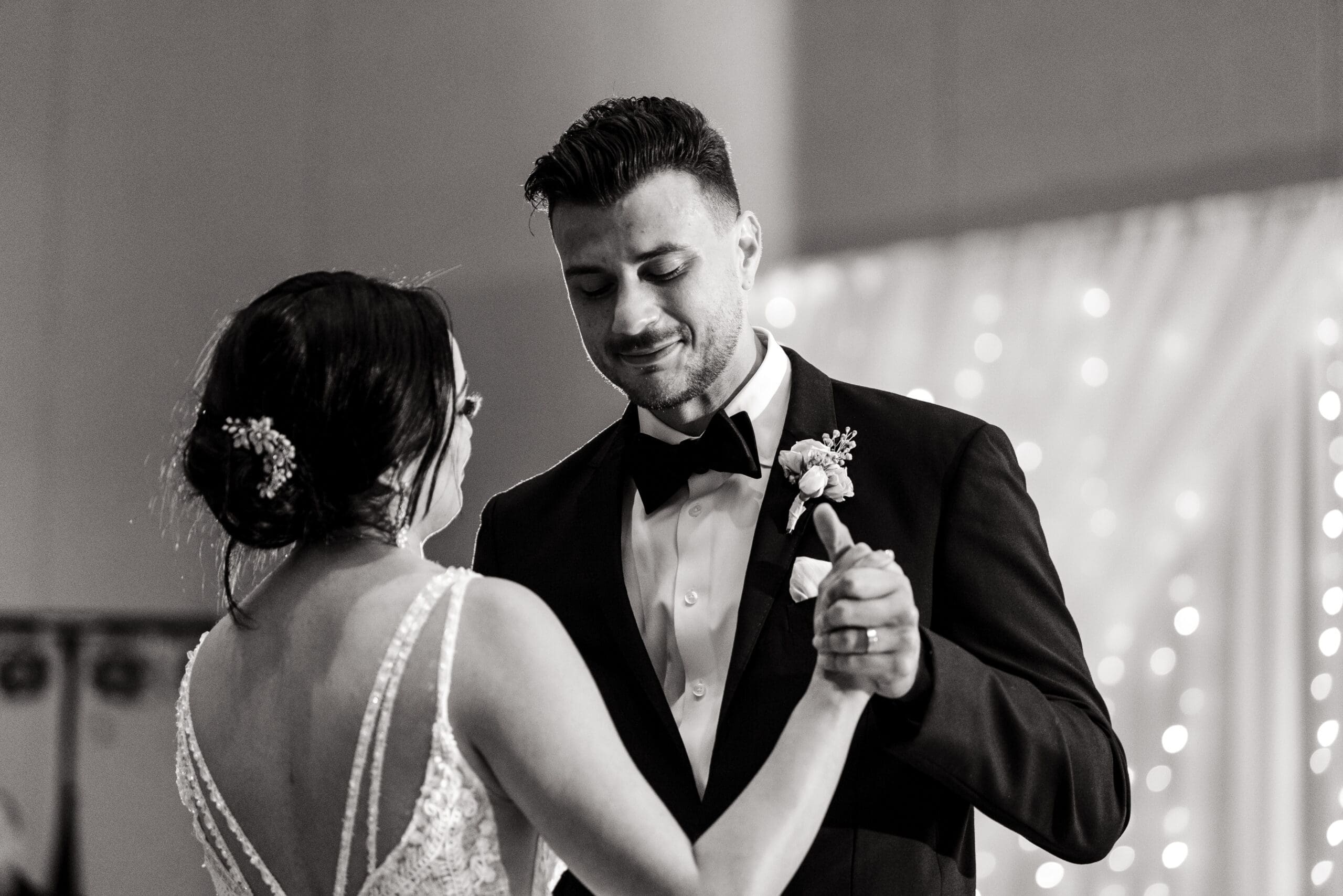 Black and white close-up shot of Jessica and Javier during their first dance at the Orlando Royale Caribe reception center, beautifully photographed by Jerzy Nieves Photography.