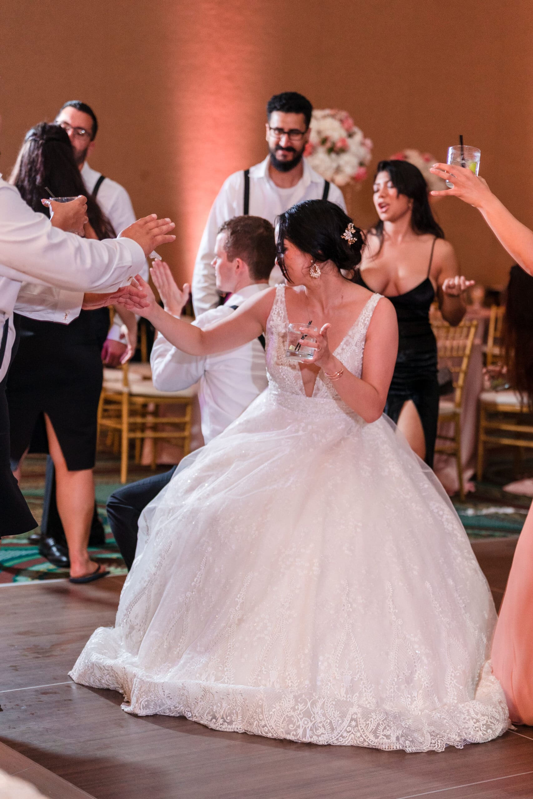 Jessica and everyone dancing at the reception, captured in a tall shot at the Orlando Royale Caribe reception center by Jerzy Nieves Photography.