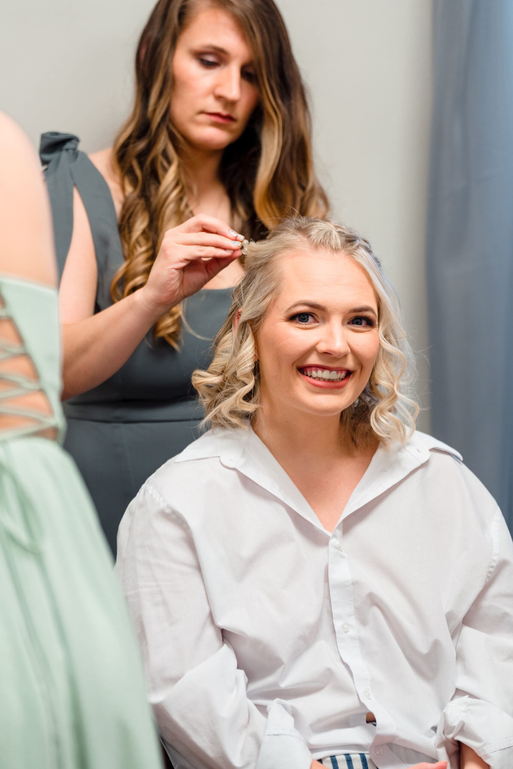 Delisa getting ready with bridesmaid assisting with her hair
