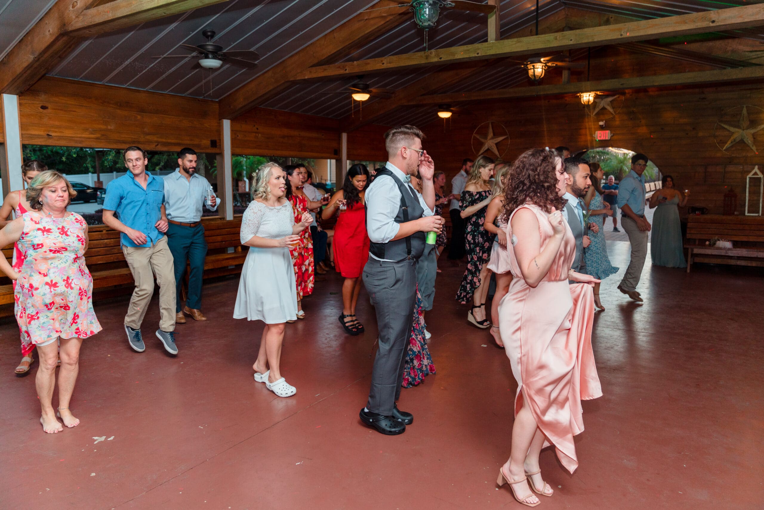 Guests doing the electric slide at the wedding reception at the Hidden Barn