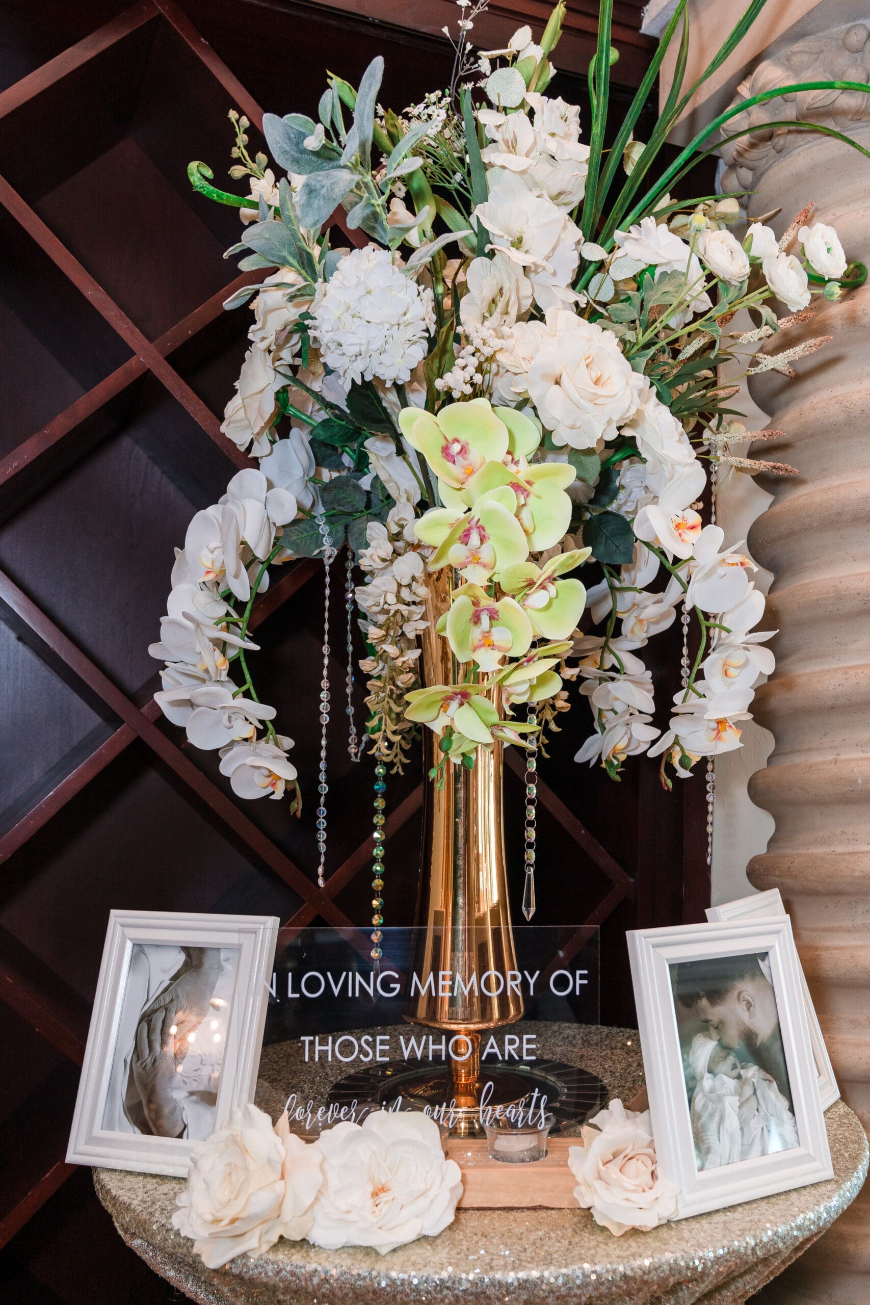Photo showing flowers and photos with the words "In Loving Memory Of Those Who Are Here in our hearts" to commemorate absent loved ones.