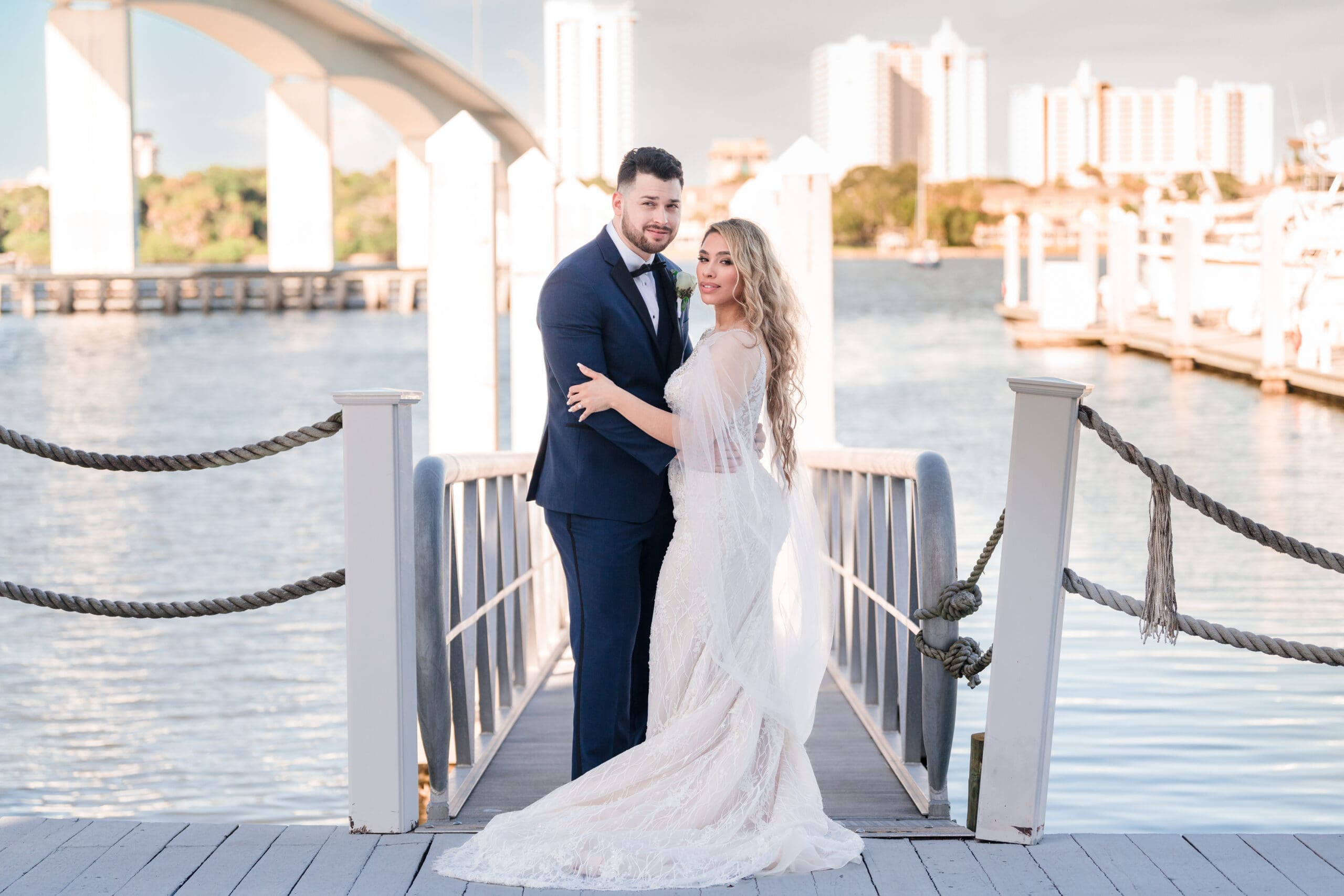 Jerzy Nieves Photography - Happy couple, dressed in traditional Indian wedding attire, holding hands on a beautiful bridge, radiating joy and love at All Inclusive Weddings Orlando