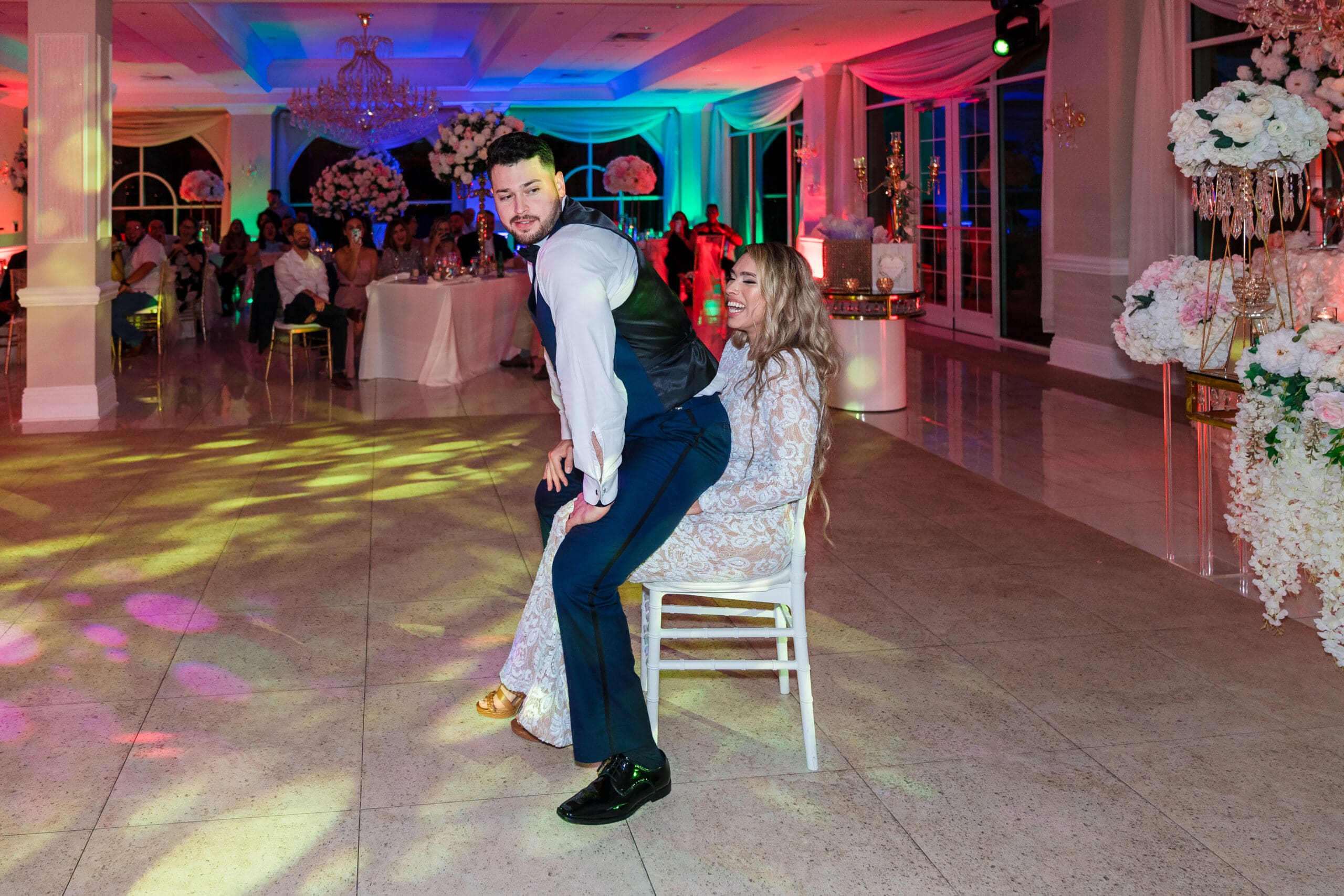 Jazer twerking for Jenn in the reception hall, with Jenn cracking up in laughter, showcasing the playful and loving dynamic of the couple, captured by Jerzy Nieves at the Crystal Ballroom.