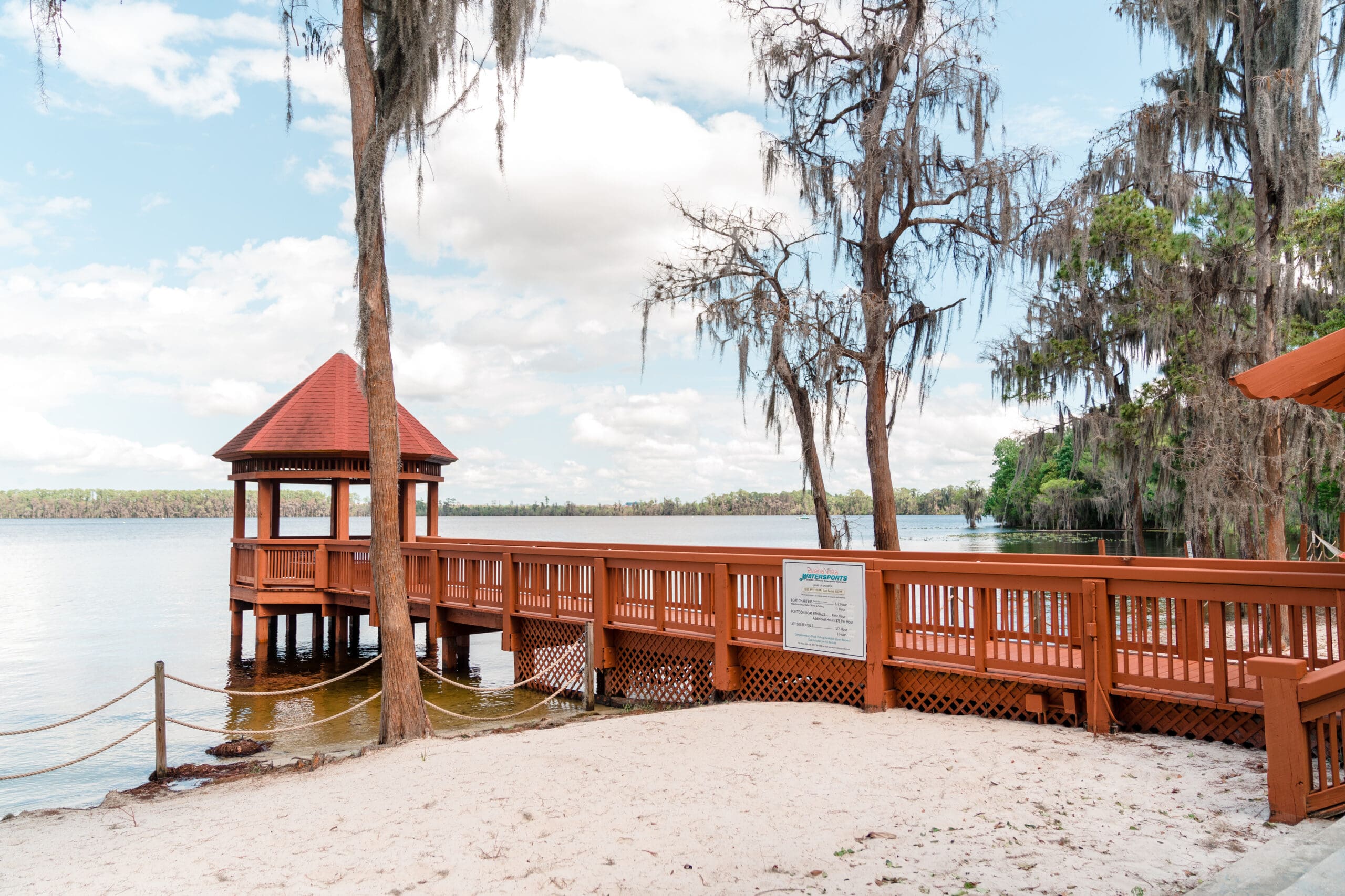 Iconic shot of Paradise Cove pier with a gazebo at the end, showcasing the sandy beach, clear water, and natural surroundings in the background.