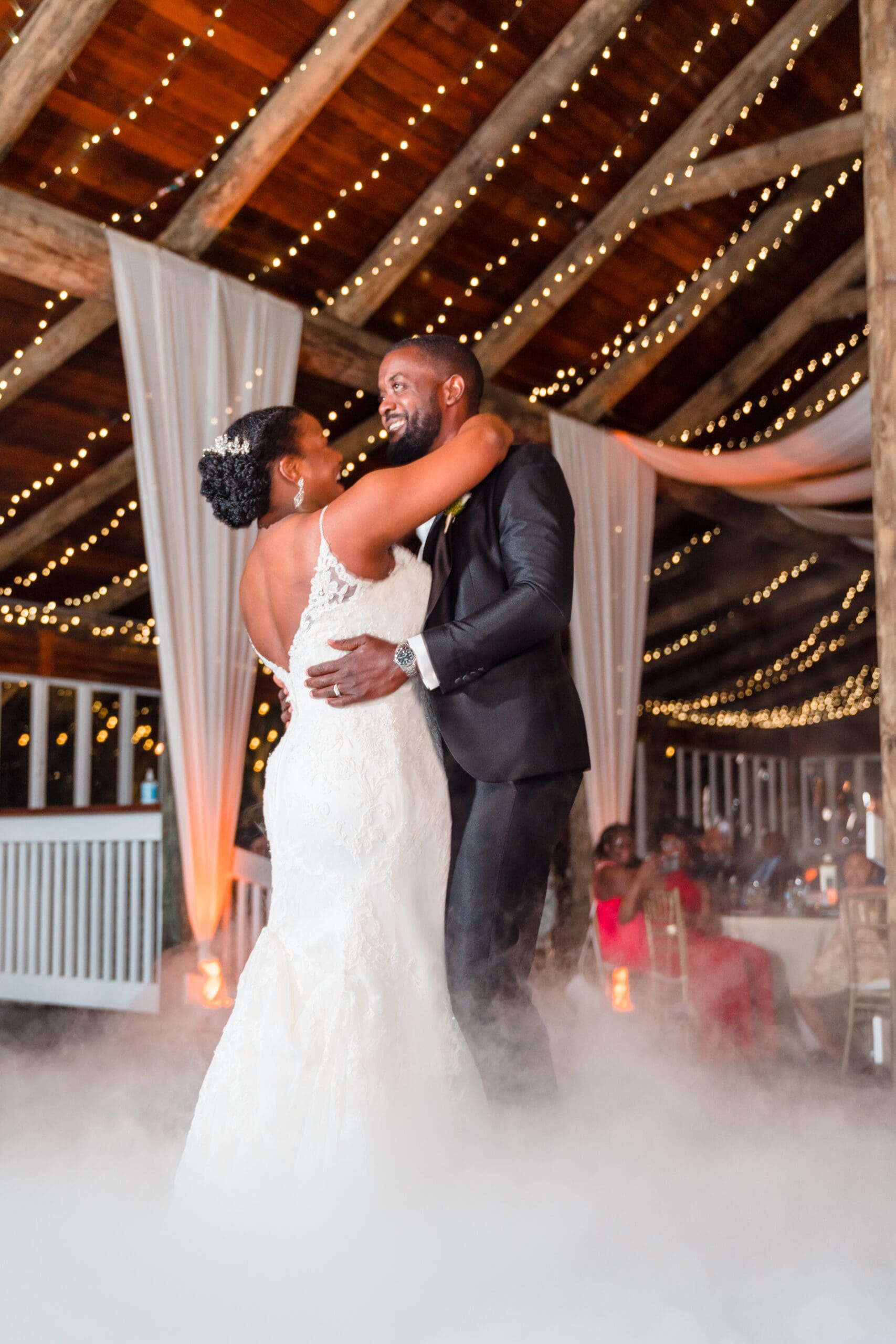 Tall shot capturing Kourtni and Jamie's first dance at Paradise Cove reception, with natural embrace and smiles amidst the mist.