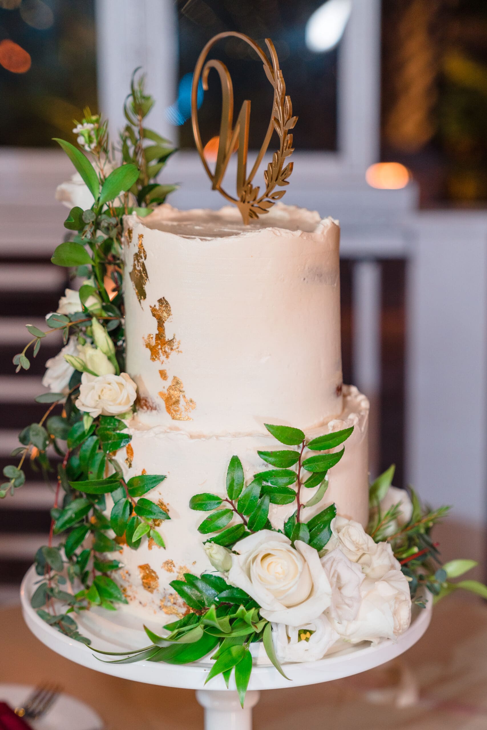 Close-up of a two-tier cake adorned with edible white flowers.