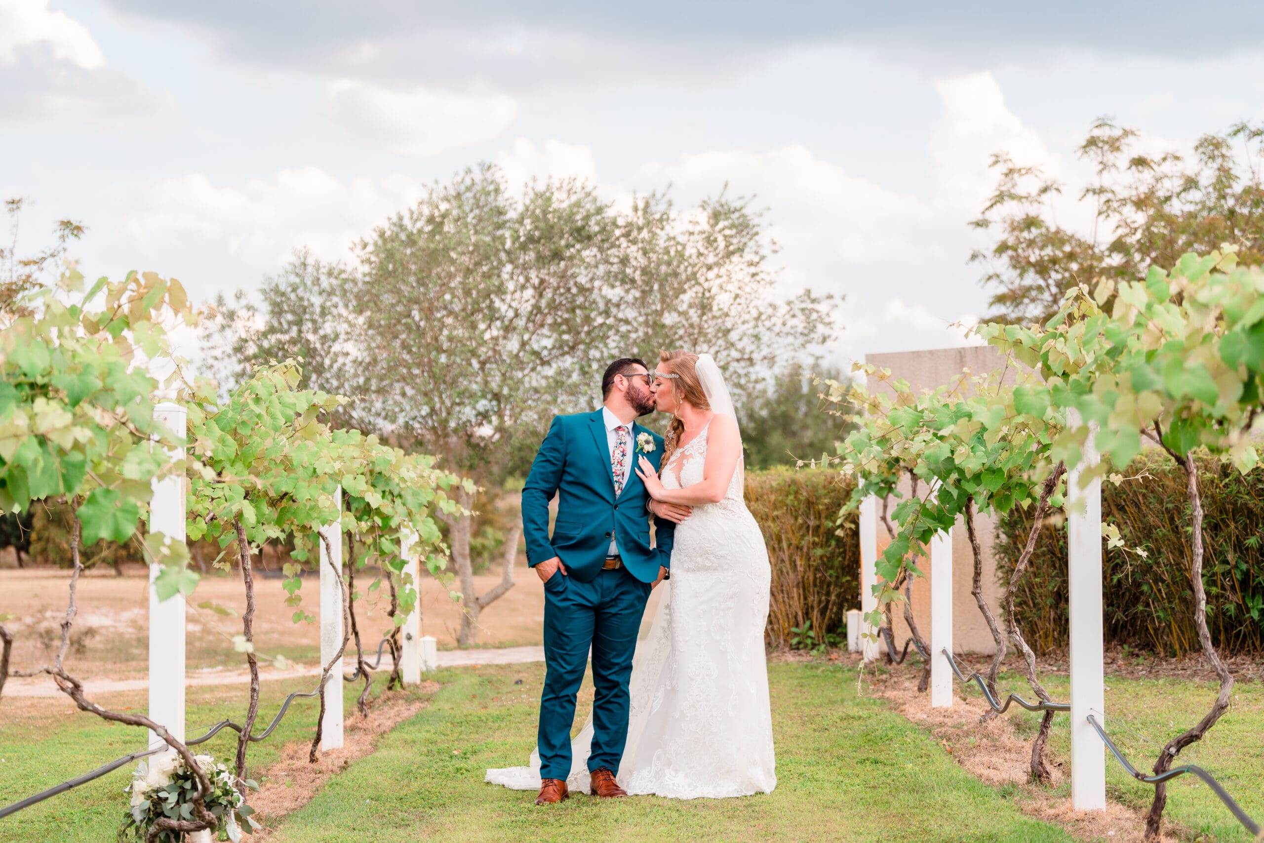 Jerzy Nieves Photography - Stylishly dressed bride and groom sharing a passionate kiss, showcasing their love and fashion-forward elegance at All Inclusive Weddings Orlando