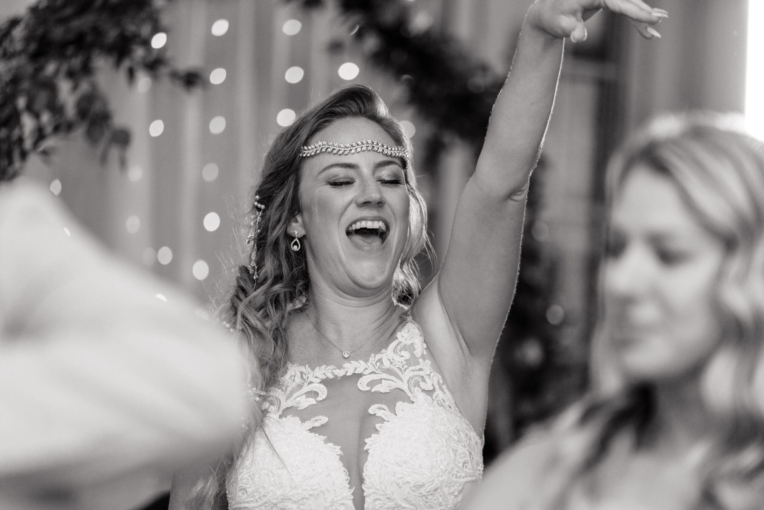 Black and white photo of Kristen having a great time at the wedding reception.