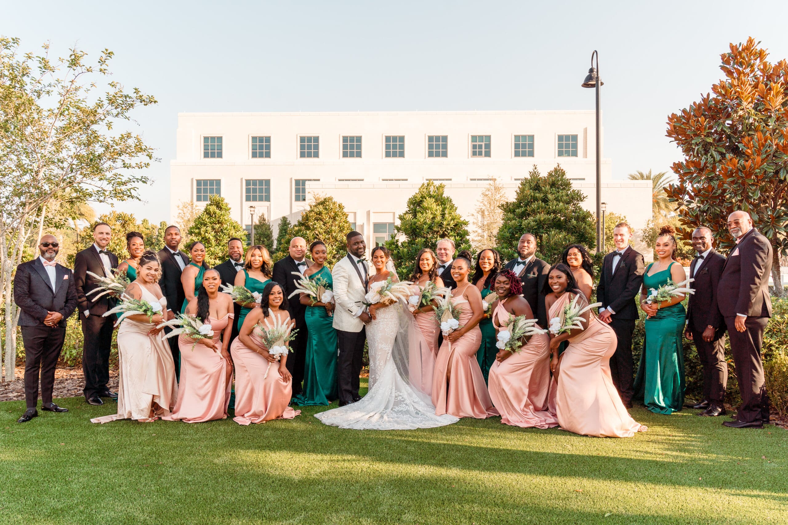 Lateisha and Glen's large bridal party posing together in front of Ocoee Lakeshore Center.