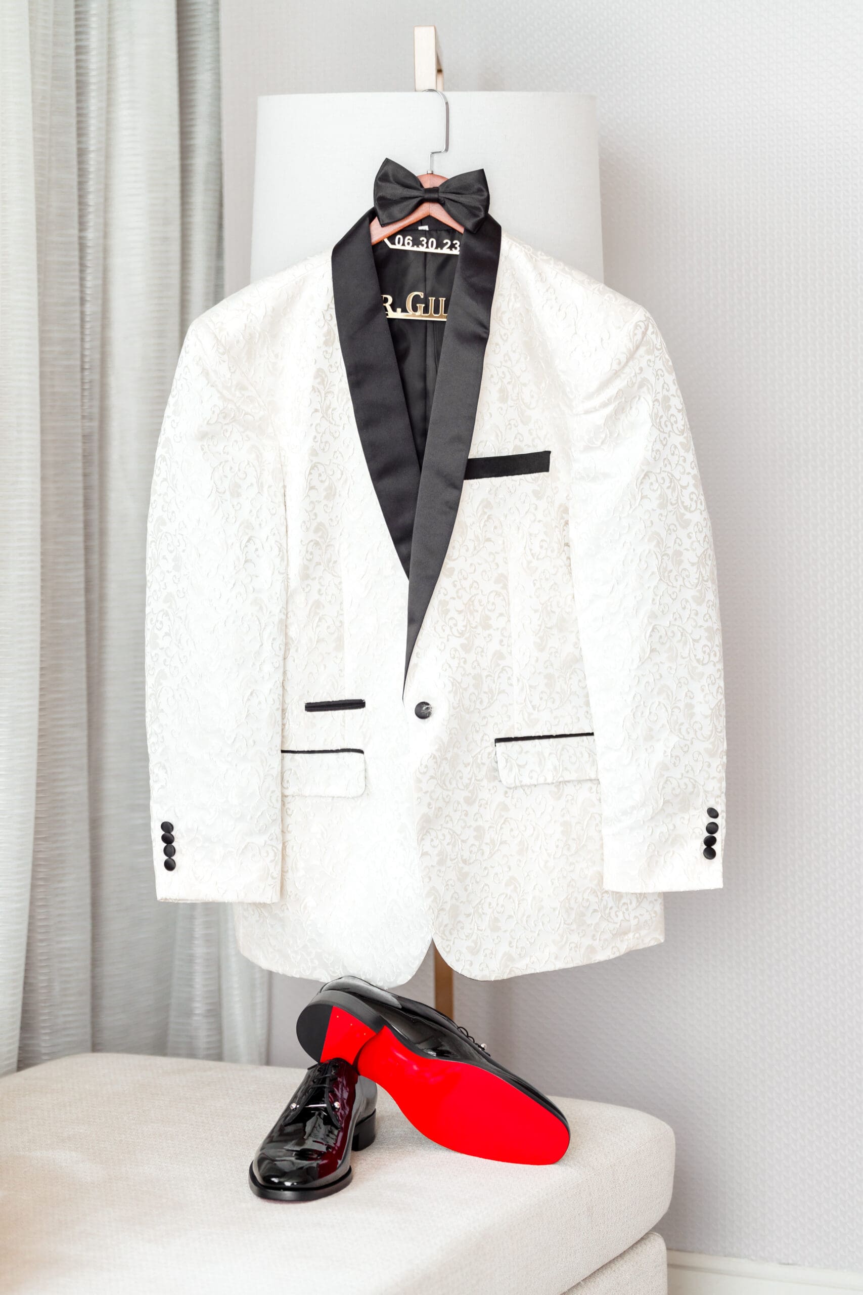 Glen's sports coat and bow tie hang neatly above his shoes, showcasing the red soles.