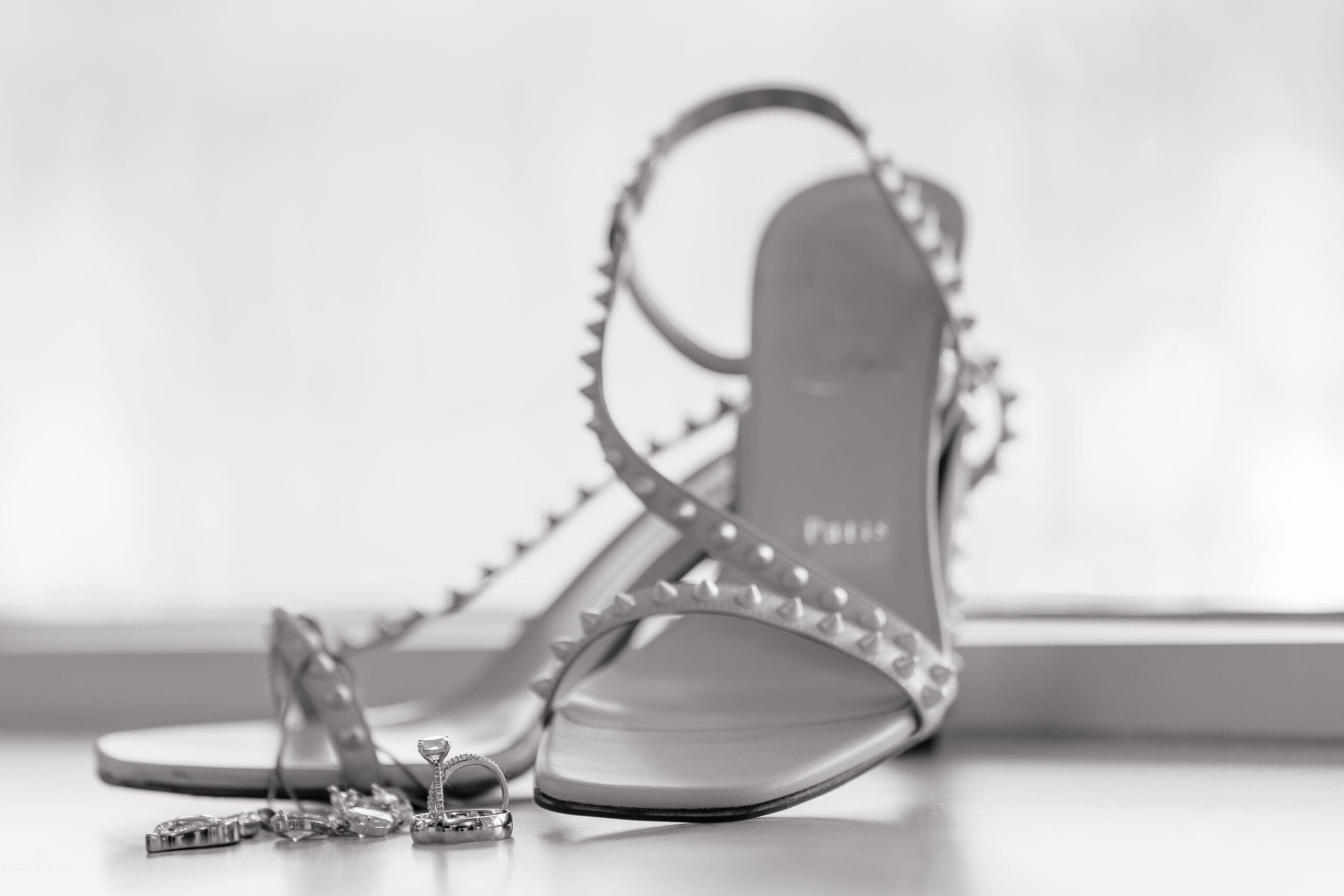 Black and white photo of Lateisha's heels, ring, and earrings.