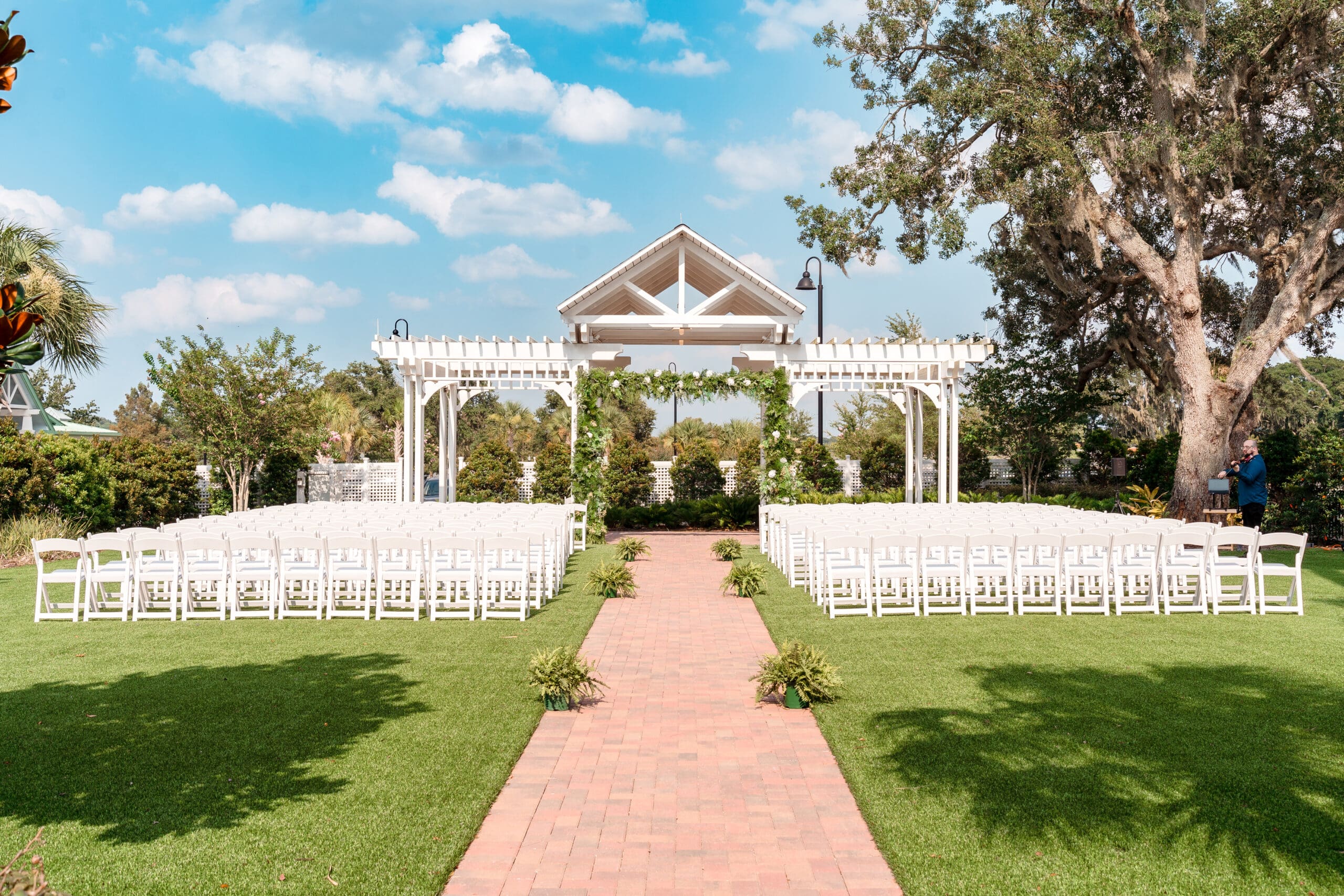 Pre-wedding shot of the outdoor altar at Ocoee Lakeshore Center adorned with greenery and white flowers.