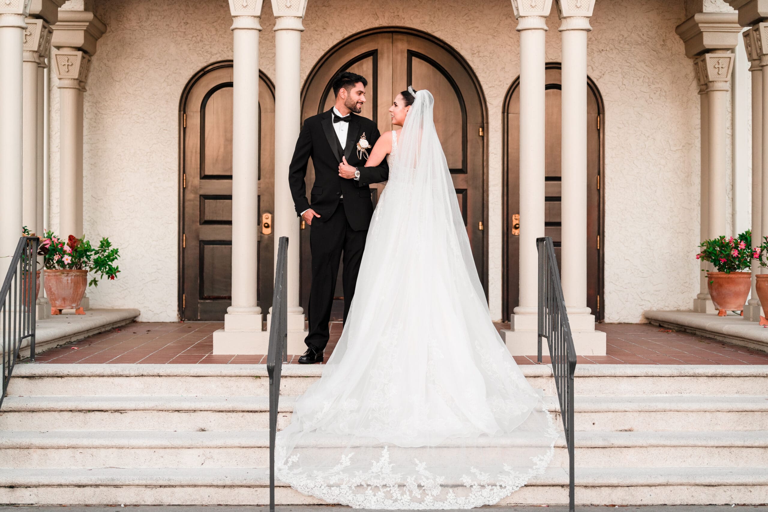 Newlyweds standing in front of arched doors at Holy Trinity Reception Center