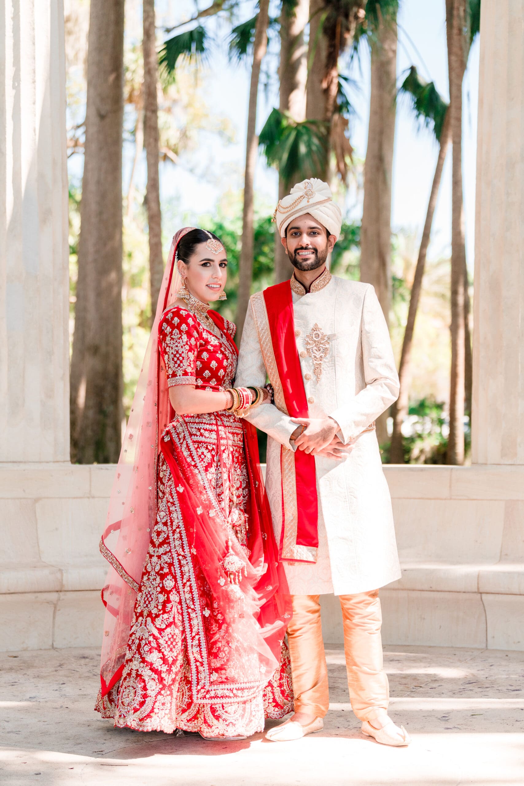 Sabrina and Rahul in traditional Indian wedding attire, standing amidst the scenic beauty of Kraft Azalea Gardens, captured in a long shot by Jerzy.