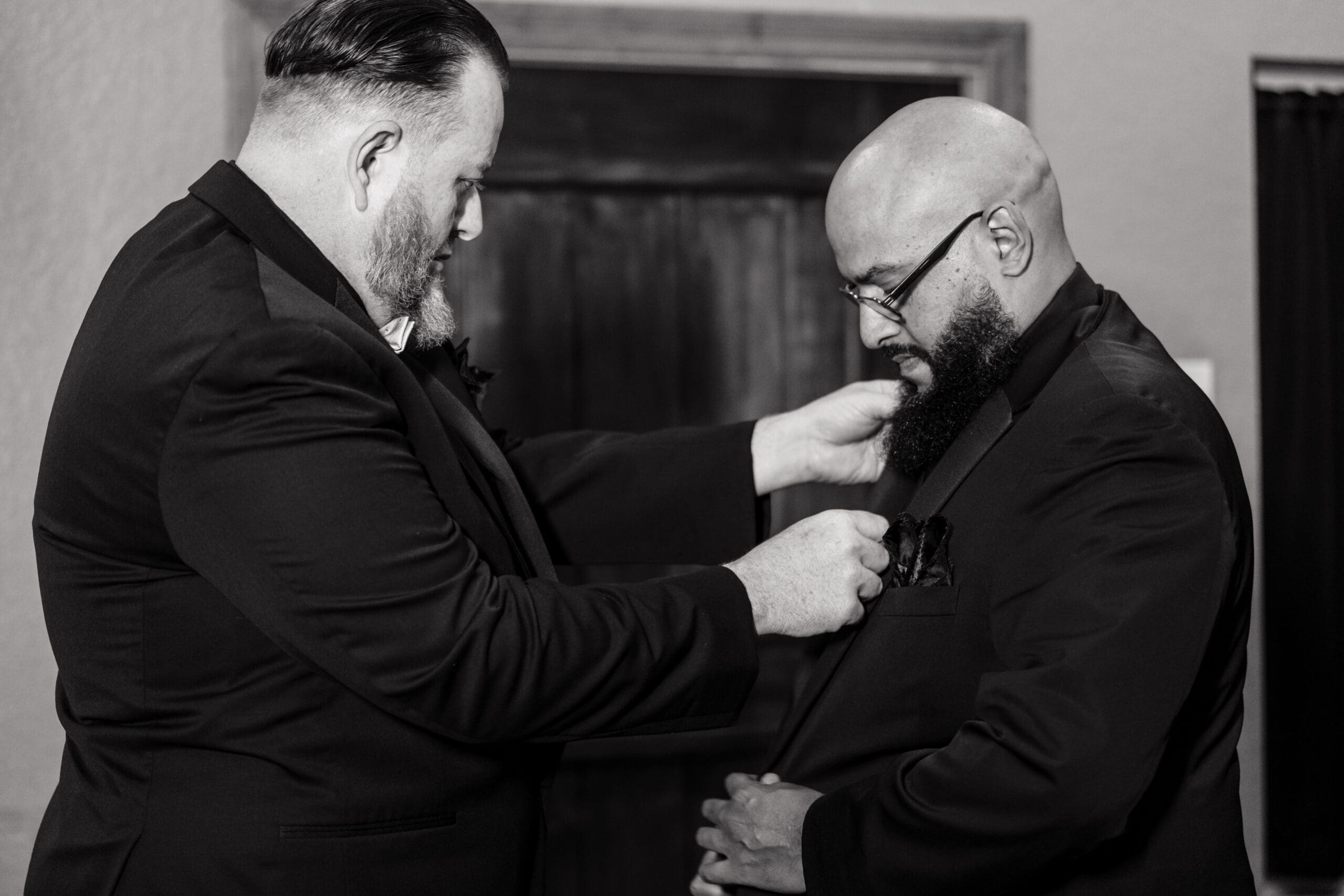 Groom David having his suit adjusted by his best man