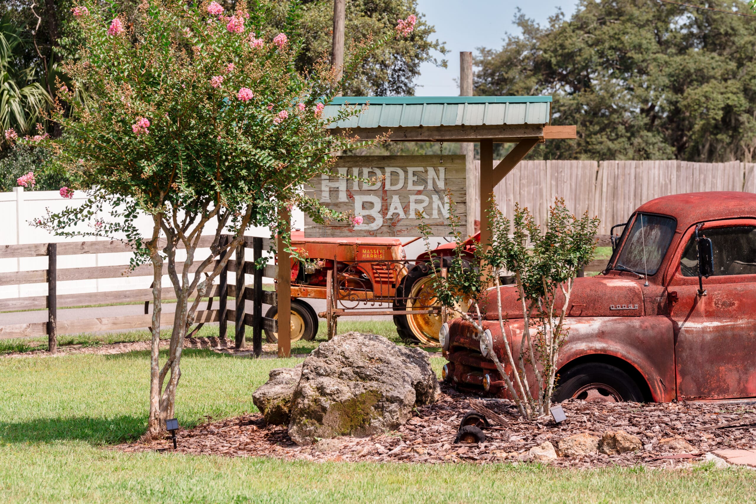 Close-up of Hidden Barn Sign Amongst Trees and Vintage Truck