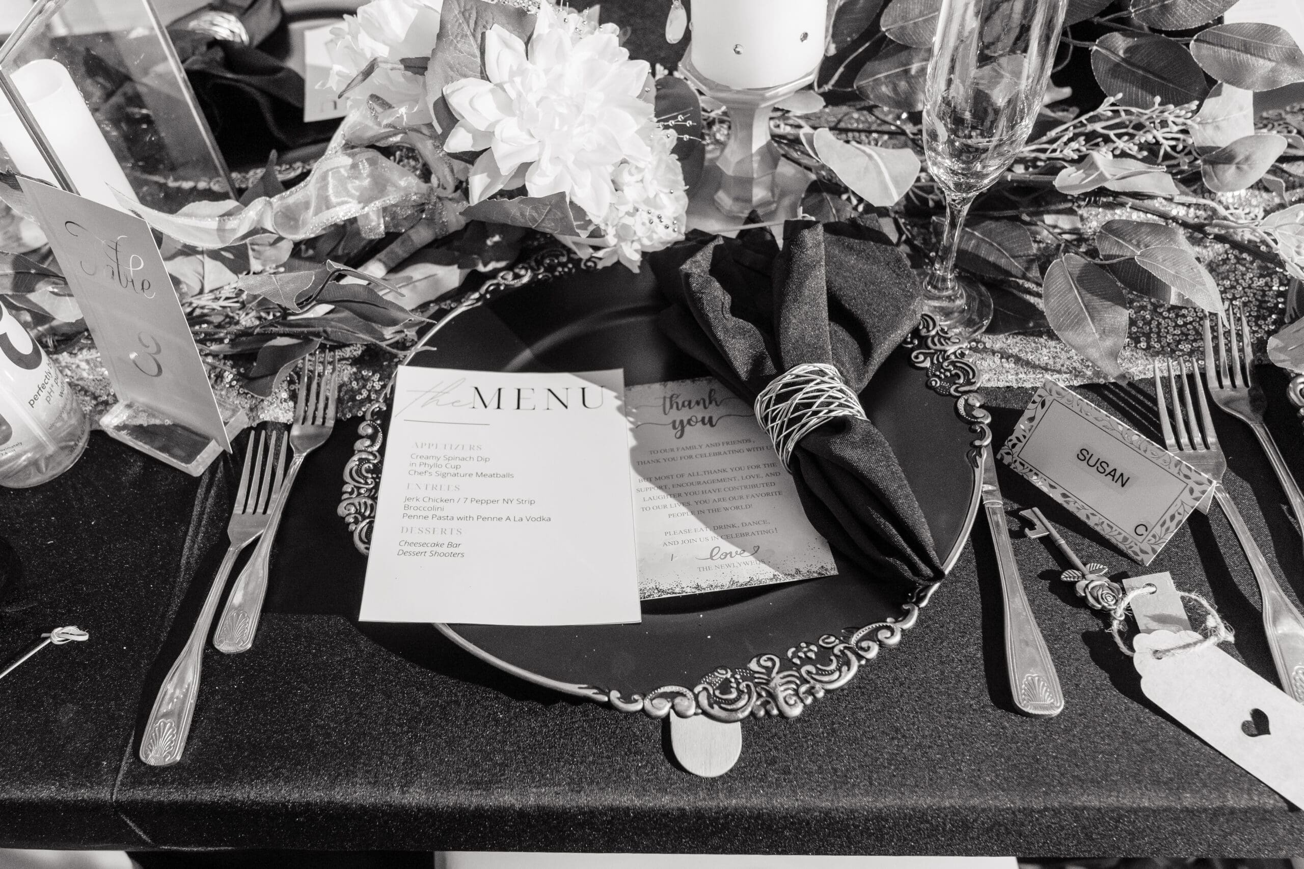 Close-up of black and gold table settings at Taylor and David's Hidden Barn wedding