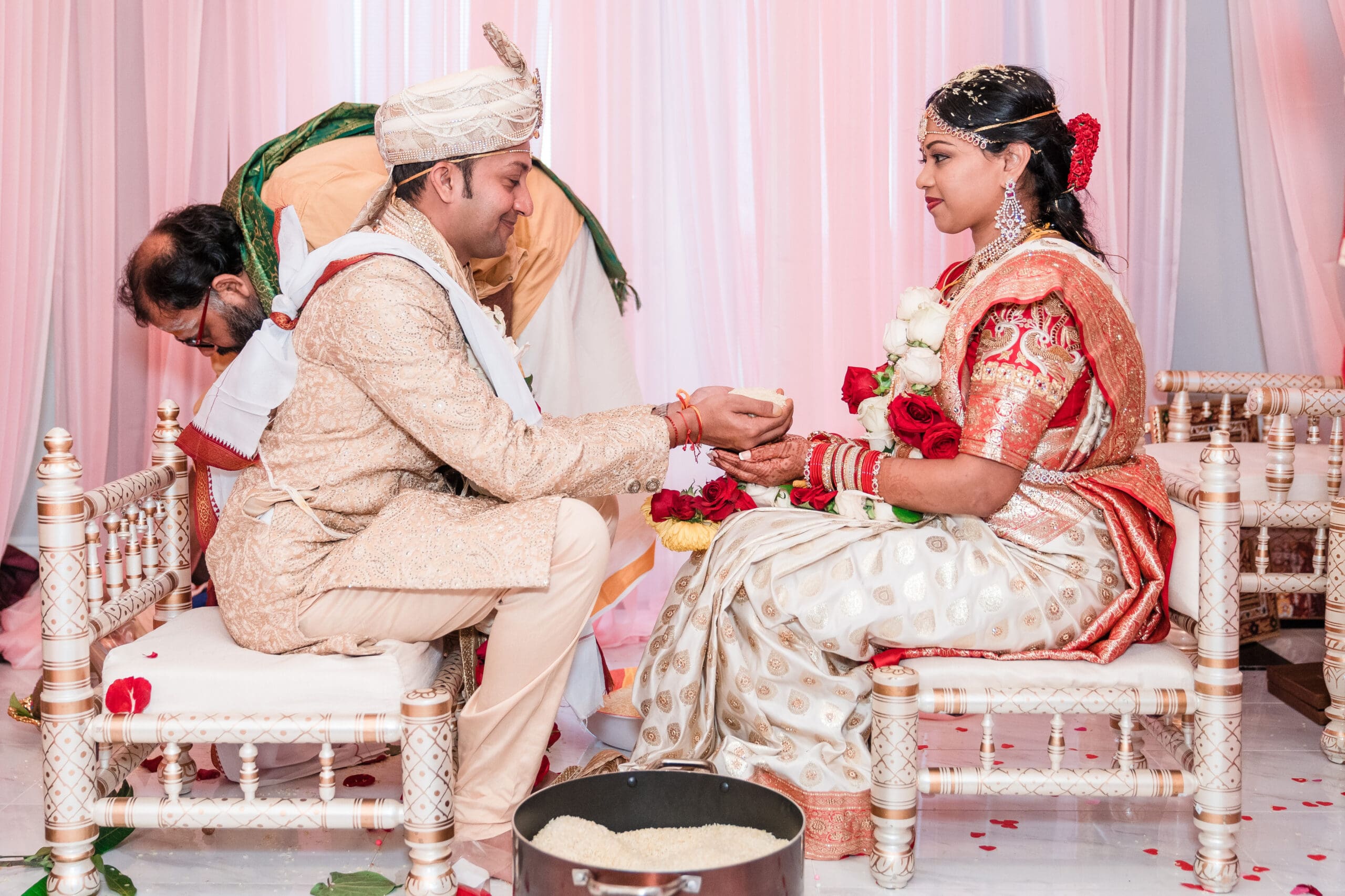 Smiling couple engaging in a cherished cultural ritual at their wedding celebration.