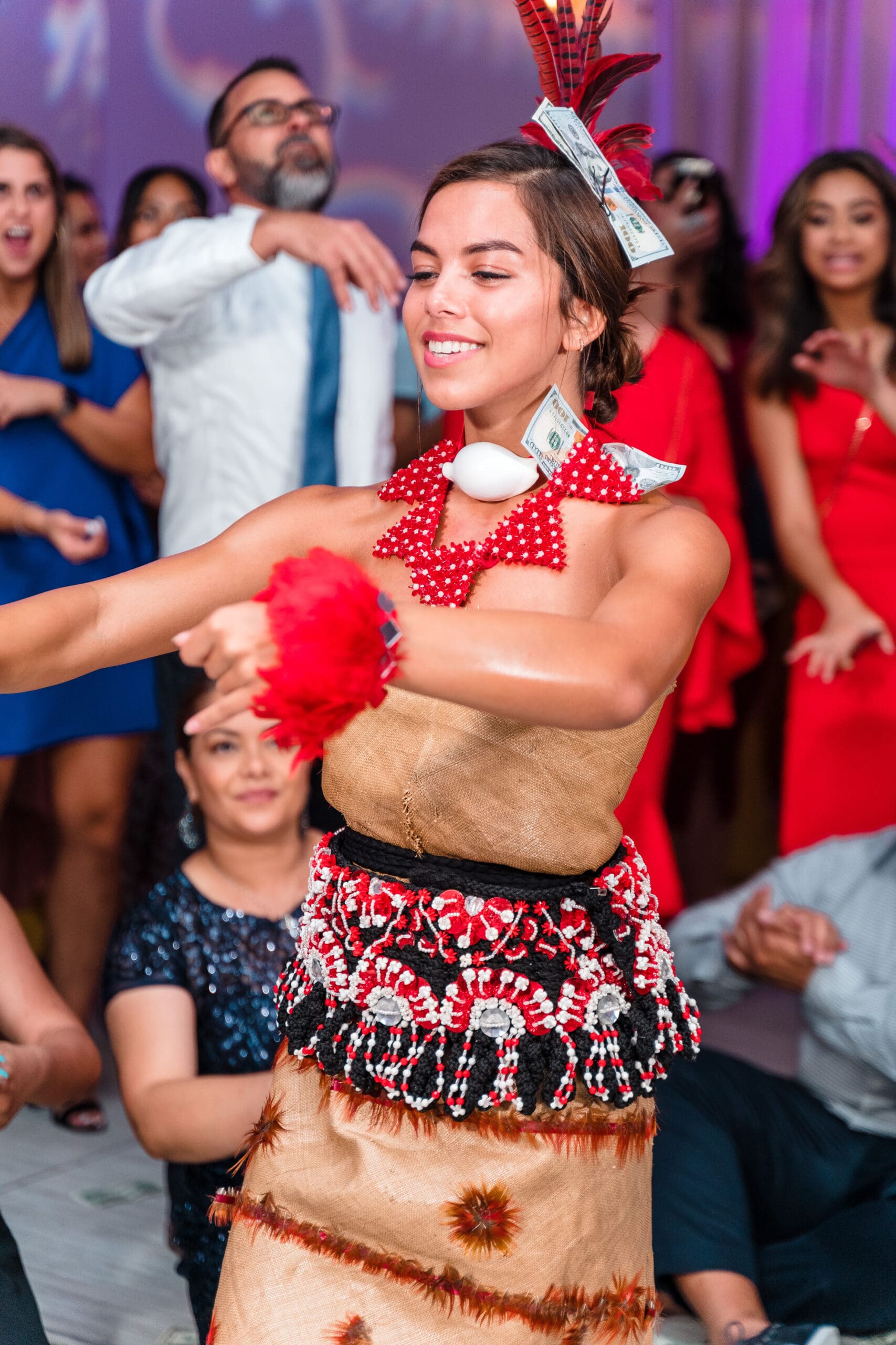 Wife in traditional Hawaiian wedding attire amidst smiling guests throwing money in celebration, with Jerzy Nieves Photography capturing the joyful moment.