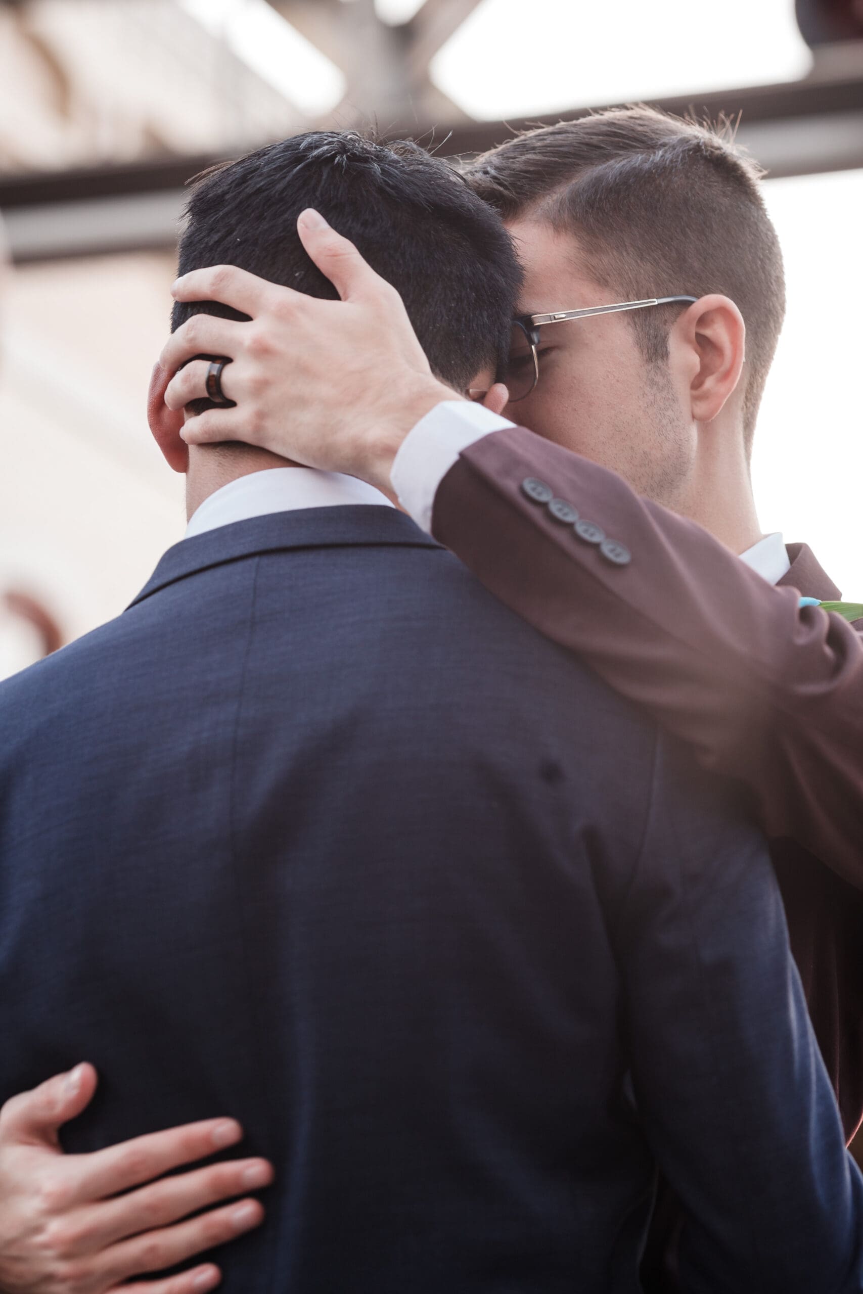 Close-up shot of two grooms embracing each other on their wedding day, showcasing the beauty of LGBTQ wedding photography.