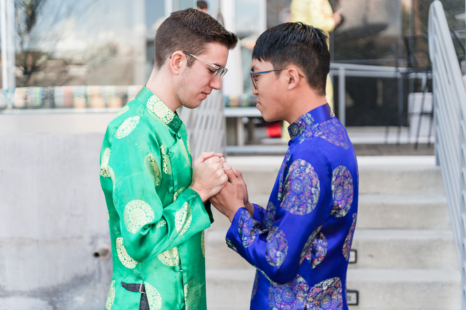 Two grooms embrace each other tenderly, holding hands in a gesture of love and devotion.
