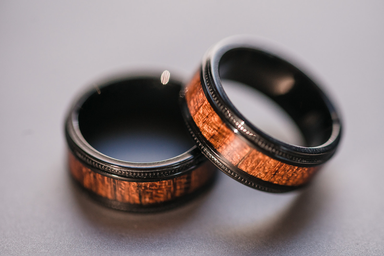 Two groom wedding bands with a unique wood grain design in the center of each band, symbolizing strength and natural beauty.
