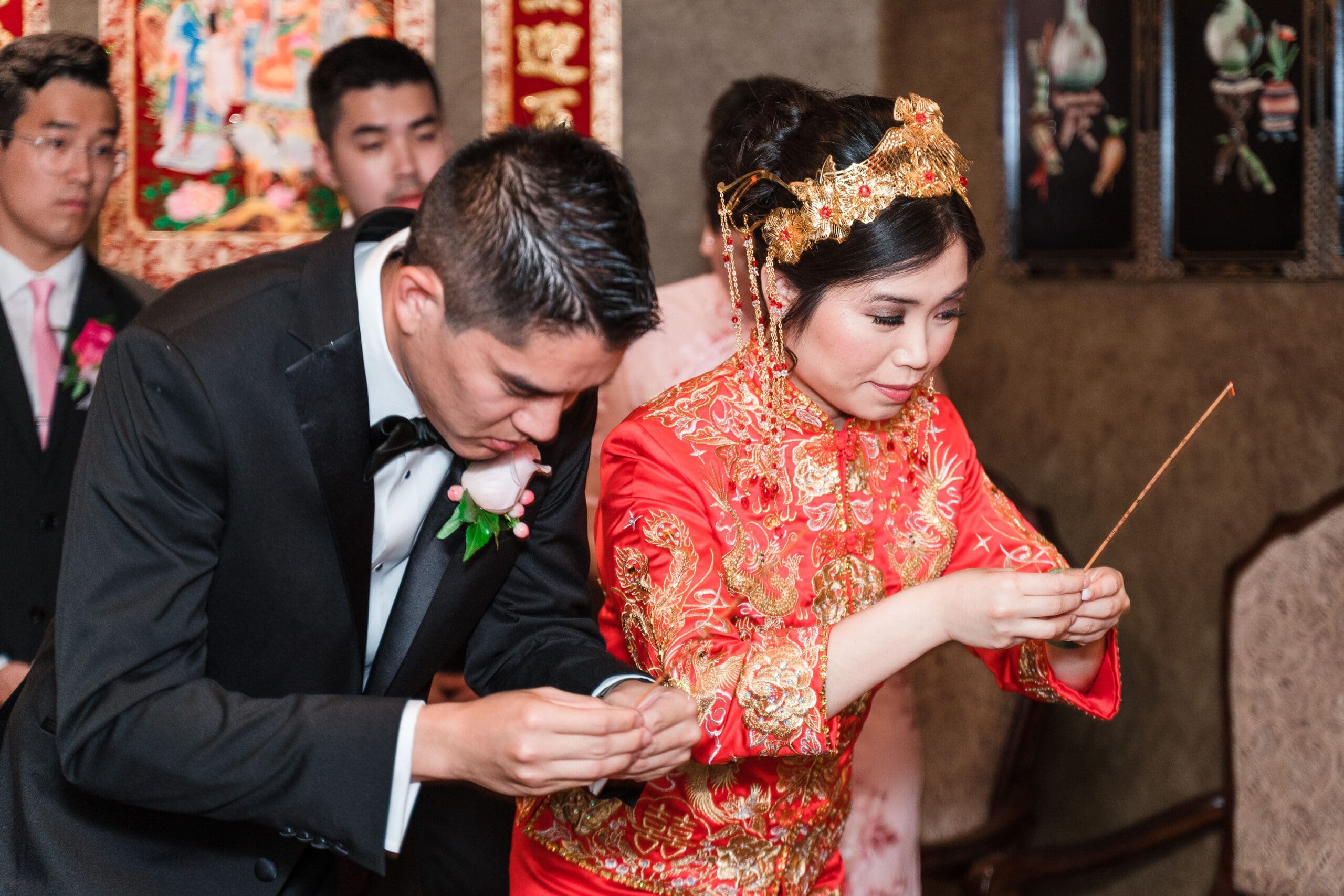 Couple bowing together at the altar in traditional Asian wedding attire
