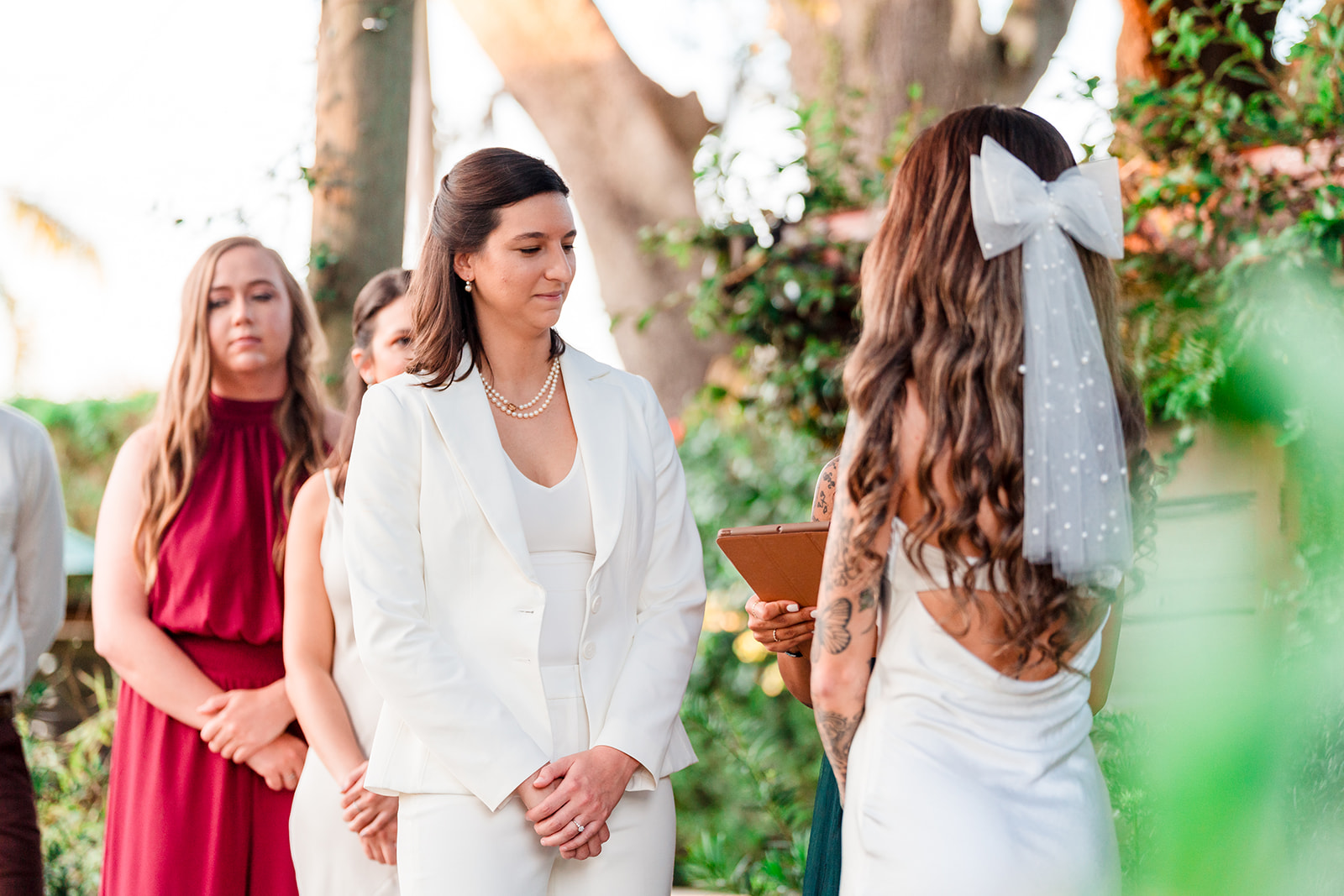Two brides stand at the altar, exchanging vows in a heartfelt moment captured in LGBTQ wedding photography.