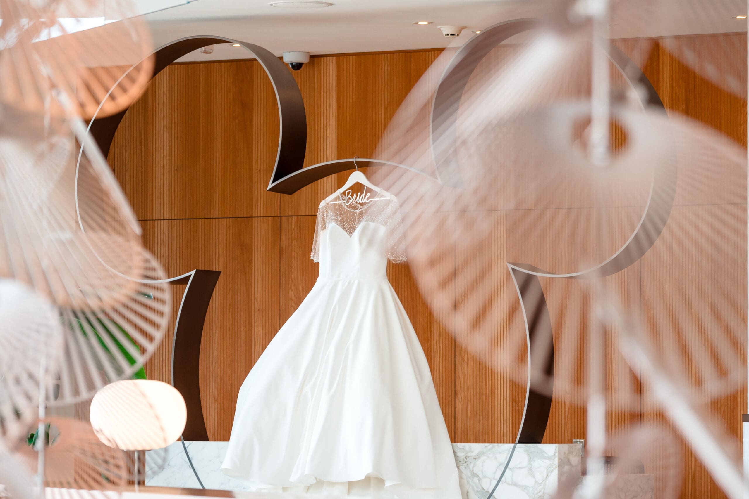 A wedding dress hanging within a wooden Mickey Mouse ear silhouette, providing a unique and charming photo opportunity.