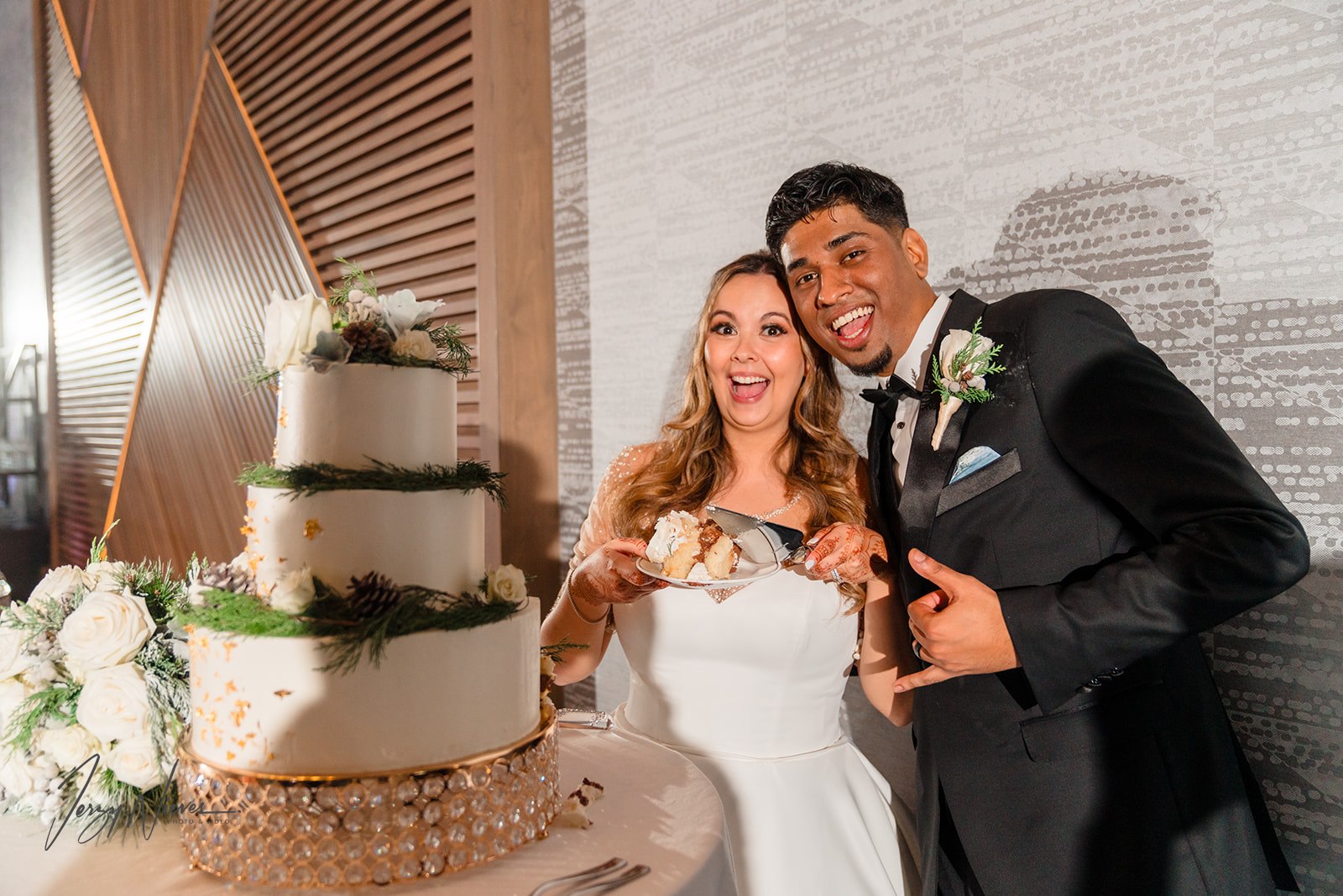 Ravin and Nicole holding slices of cake, smiling for the camera at Disney Swan Reception Hall