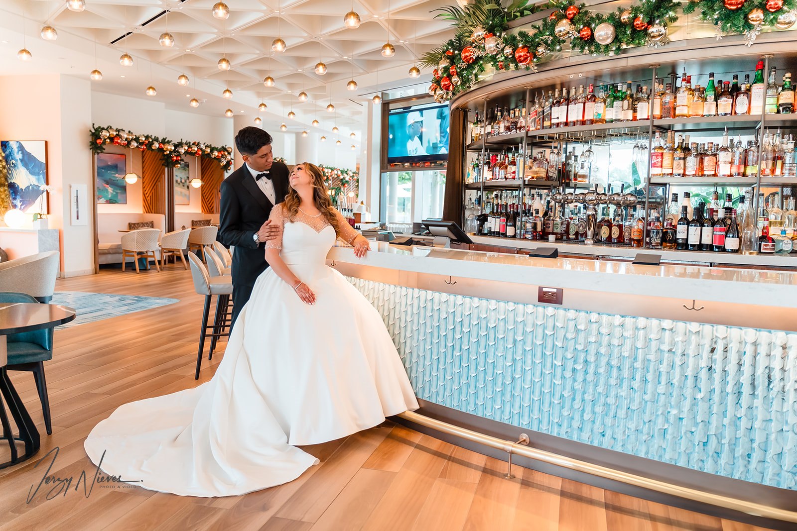 Ravin and Nicole wearing traditional American wedding attire, looking into each other's eyes at the elegant bar in Disney Swan Reserve.