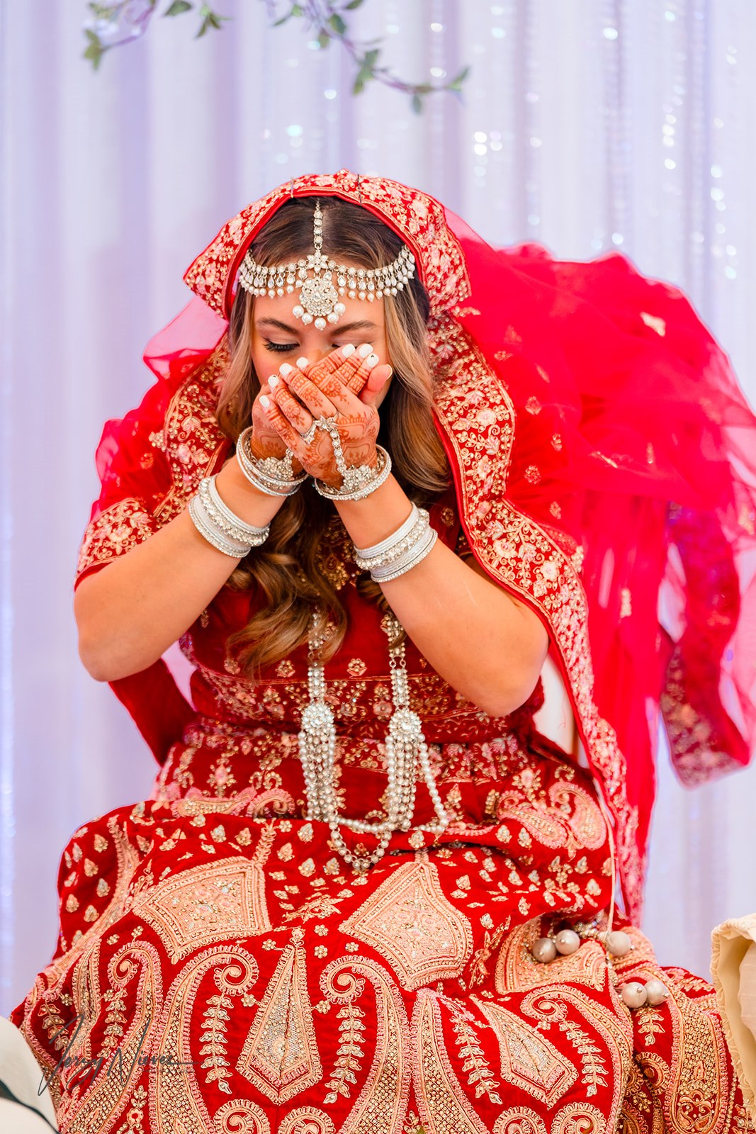 Close-up of Nicole seated in a chair adorned with henna tattoos, participating in the traditional Indian wedding ceremony at Disney Swan Reserve.