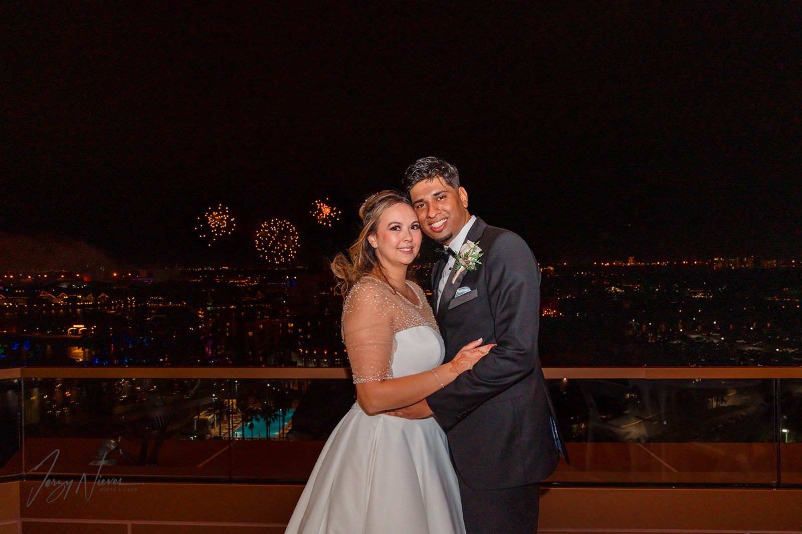 Nicole and Ravin on balcony with Disney fireworks in background at Disney Swan.