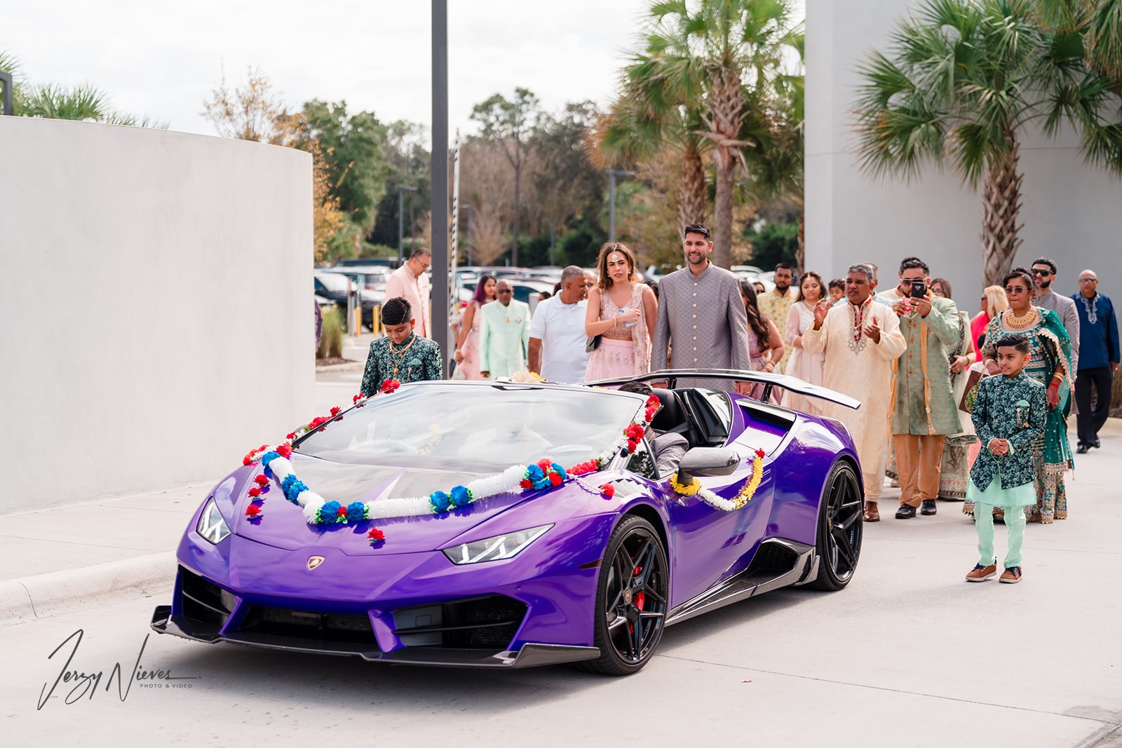 Javin drives a purple Lamborghini Huracan at the beginning of a parade.