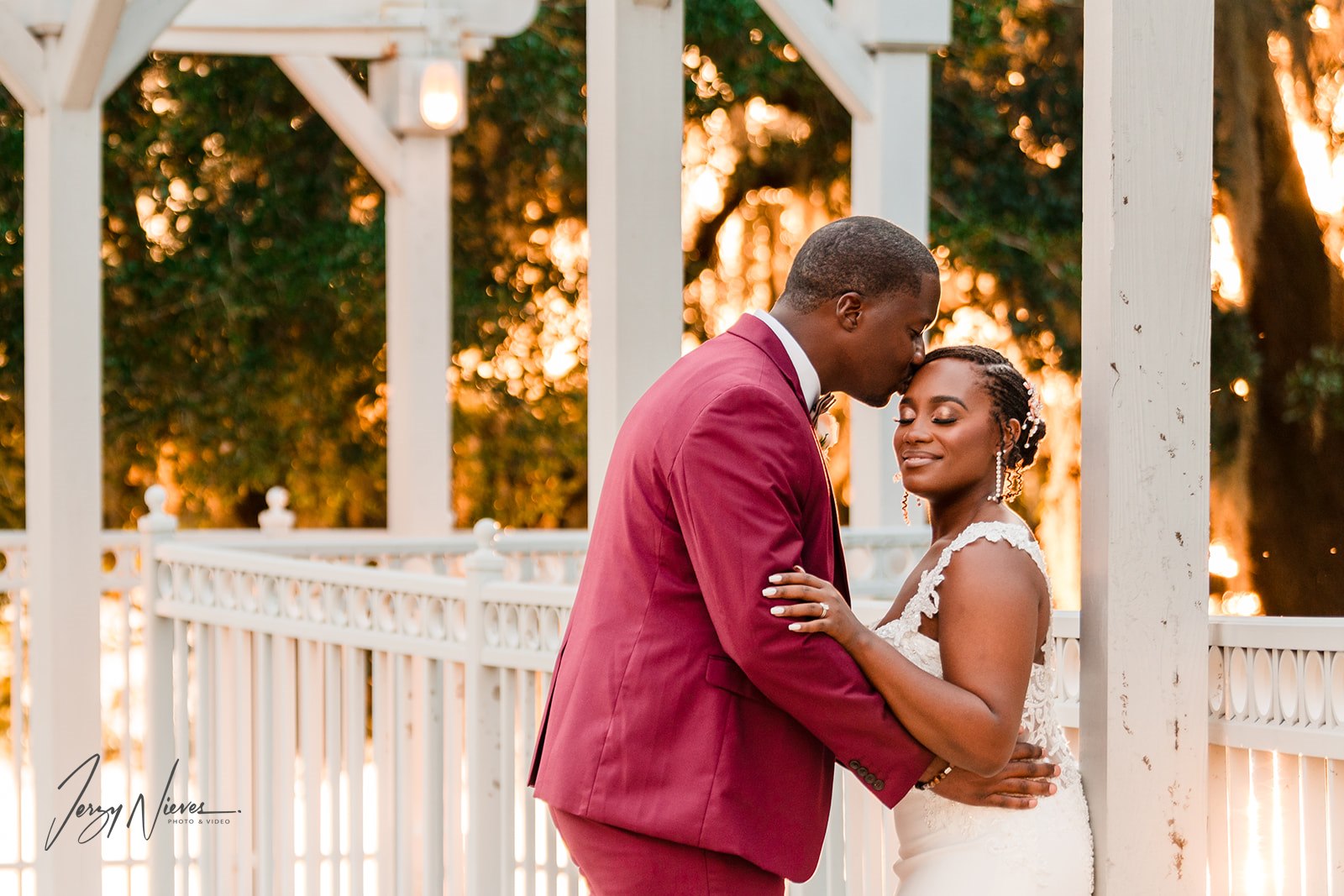 Javon kissing Shelby's forehead against a pillar in the outdoor walkway at Lake Mary Event Center.