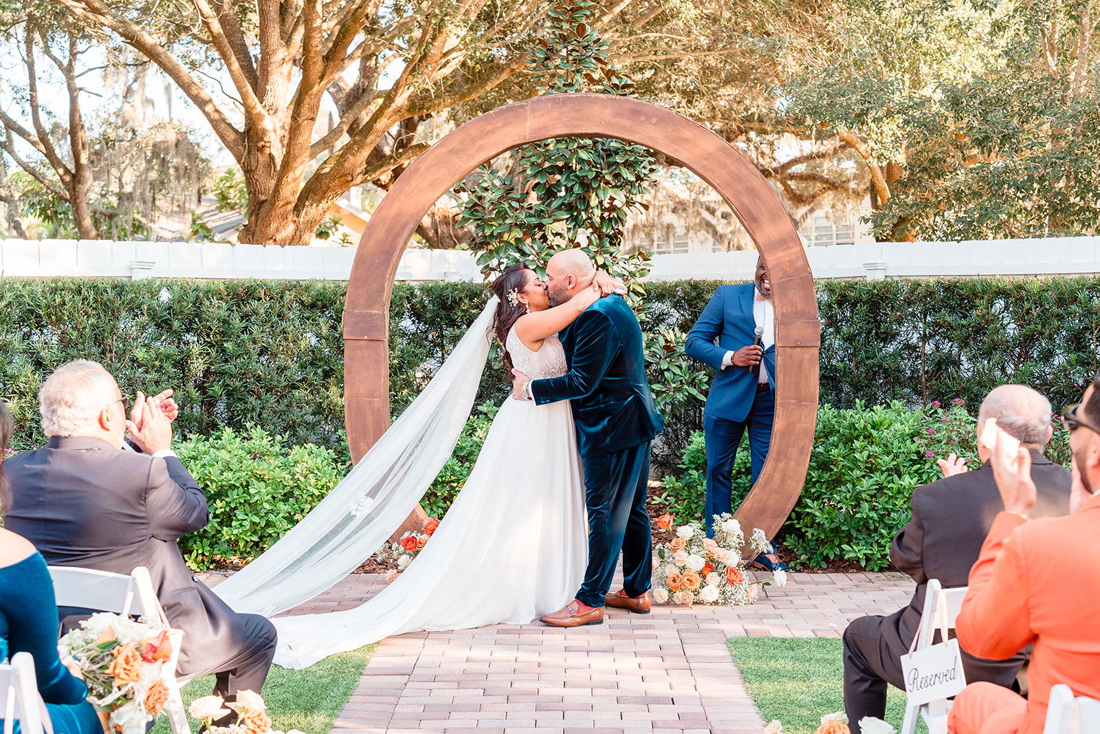 Close-up of the altar at Venue 1902's garden ceremony area, capturing the bride and groom sharing a kiss at the end of the ceremony.