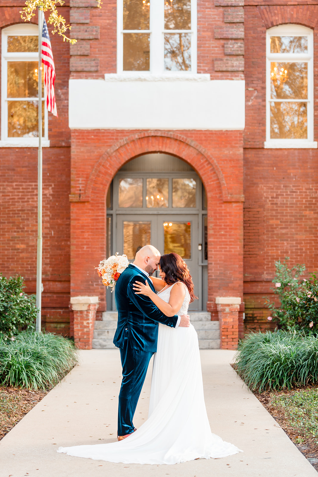 Couple embracing at the front of Venue 1902, touching foreheads in a tender moment.