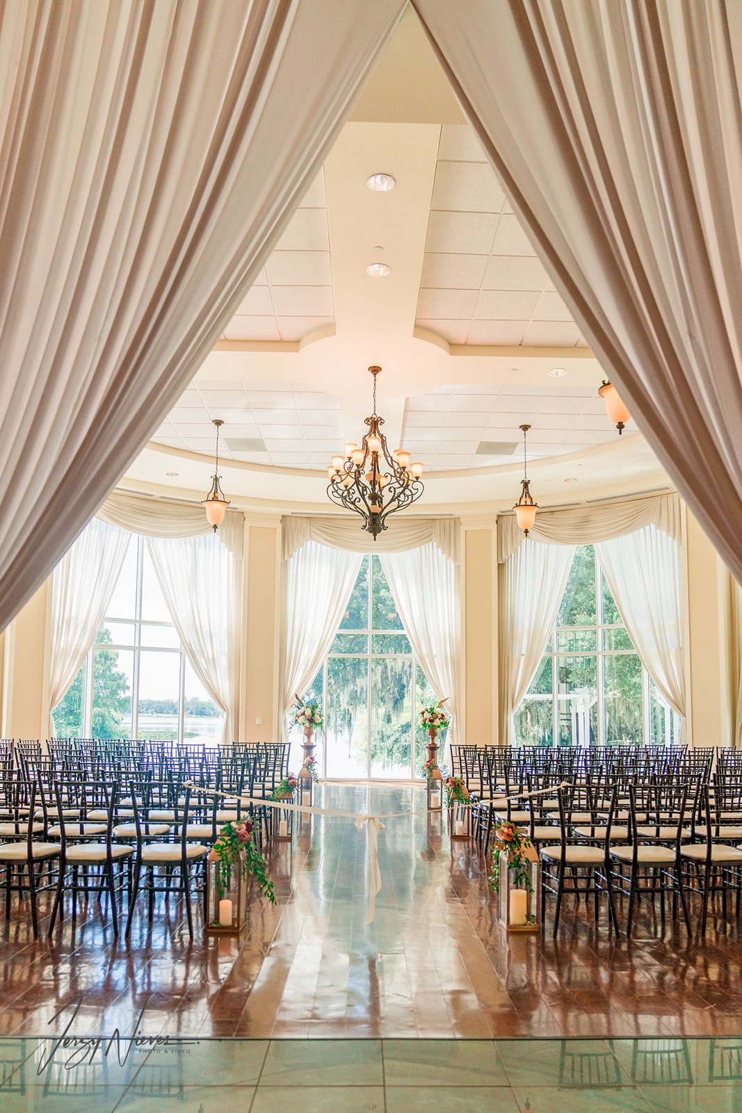 Tall shot of Lake Mary Event Center's ceremony room, showcasing tall ceilings and elegant lighting