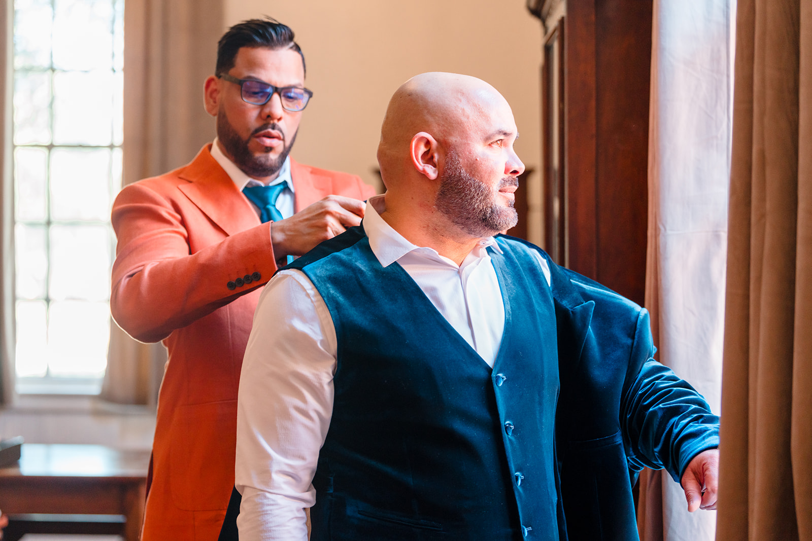 Pre-wedding moment: Best man helping Alberto with his sports coat as he gazes out the window at the beauty of Venue 1902.