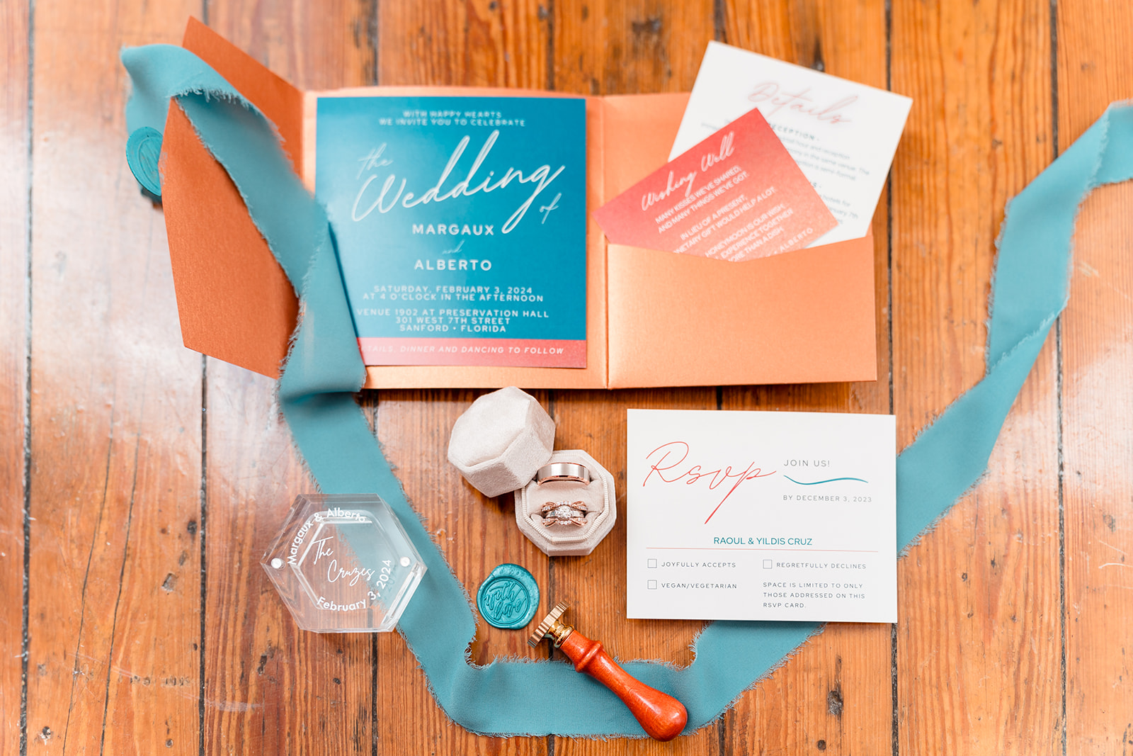 Close-up shot of wedding invitation and rings resting on a wooden table at Venue 1902.