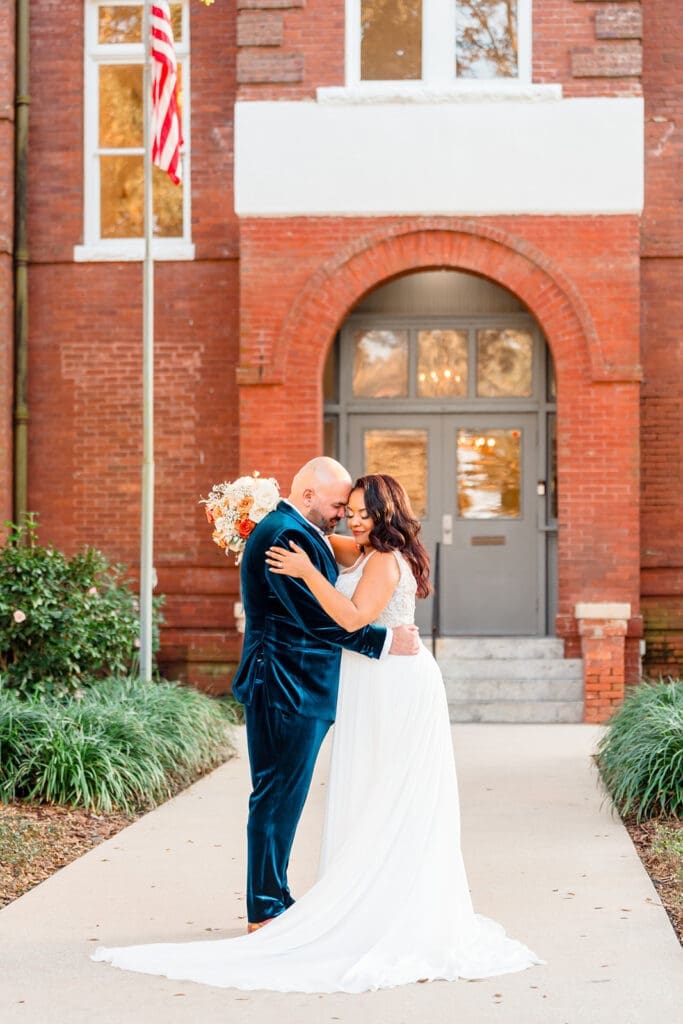 Margaux and Alberto embracing as newlyweds outside the front of Venue 1902, captured by Jerzy Nieves Photography.