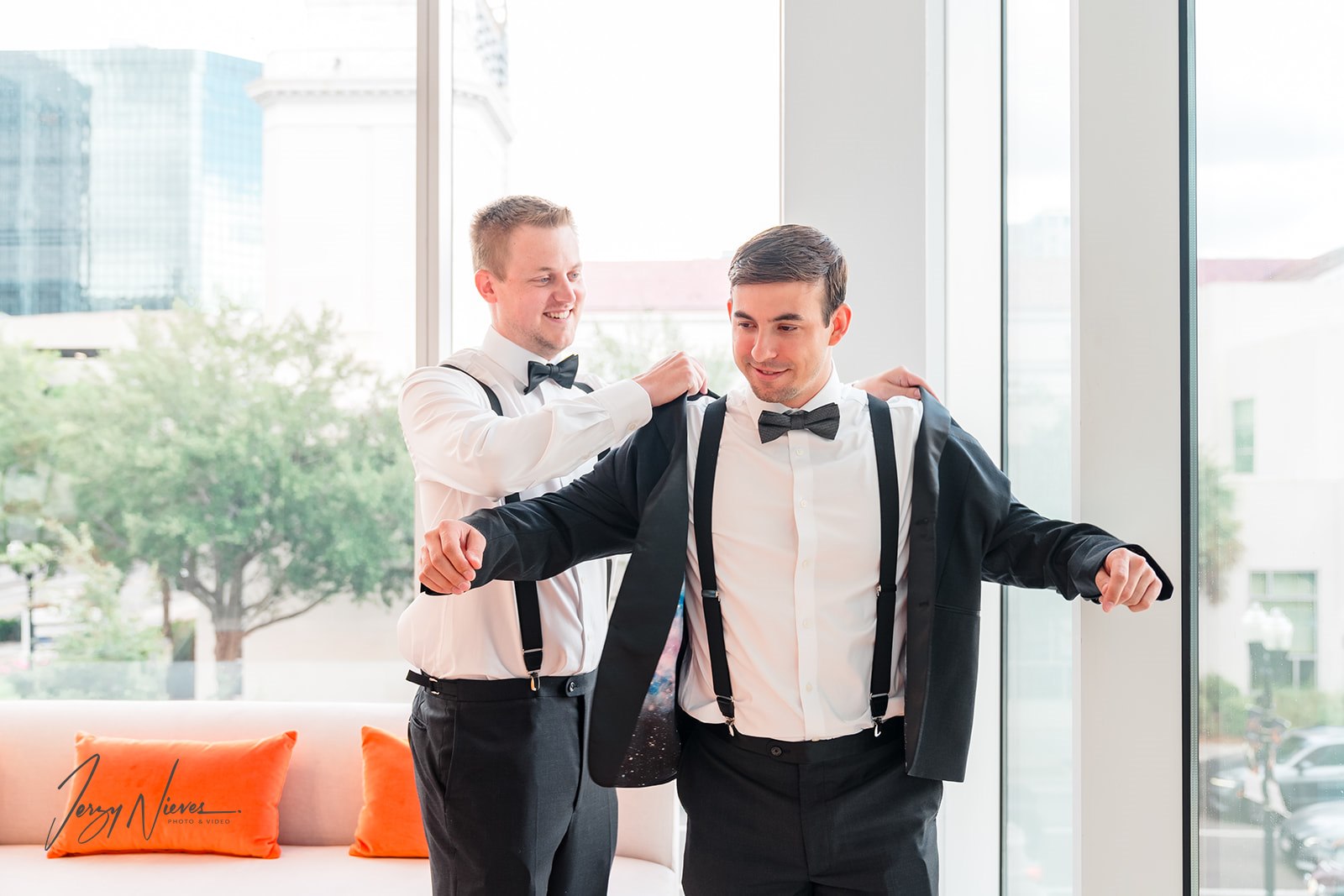 Best man helping the groom with his sports jacket pre-wedding.
