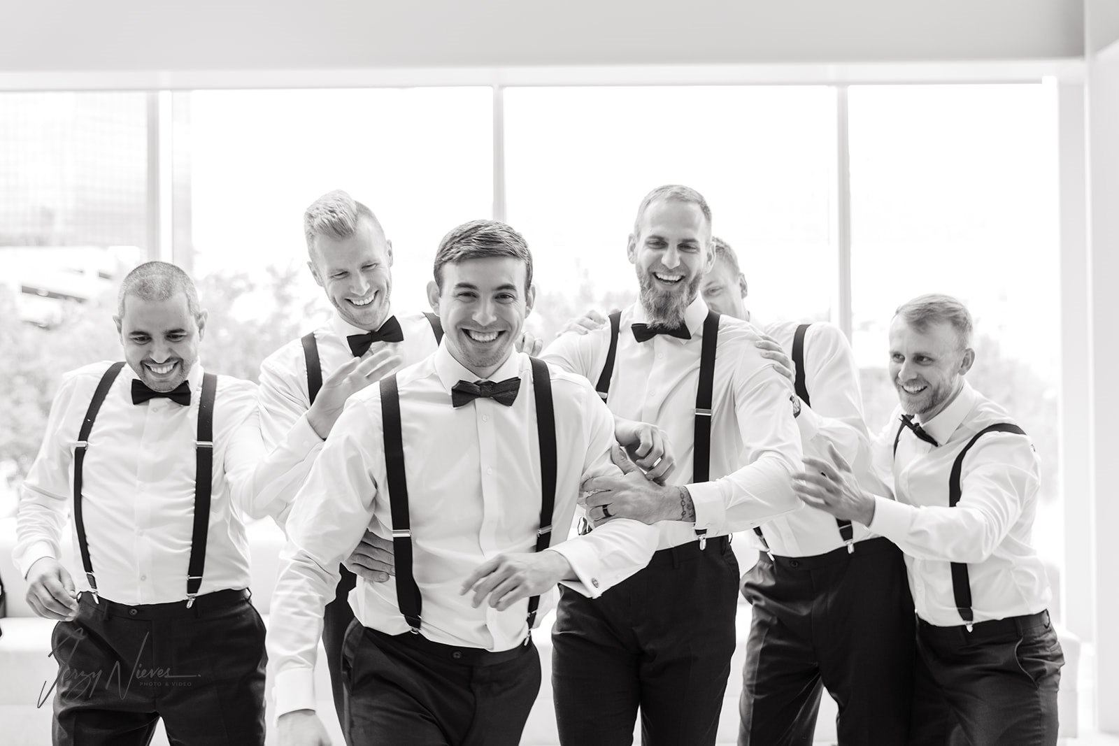 Black and white photo of the groom and his groomsmen goofing around without sports jackets on.