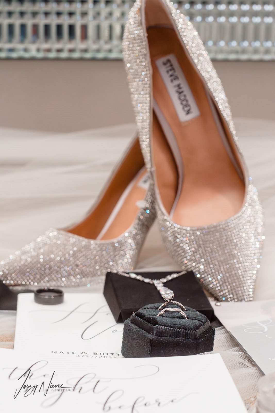 Close-up shot of bride Brittany's Steve Madden heels, wedding rings, and wedding invitations.