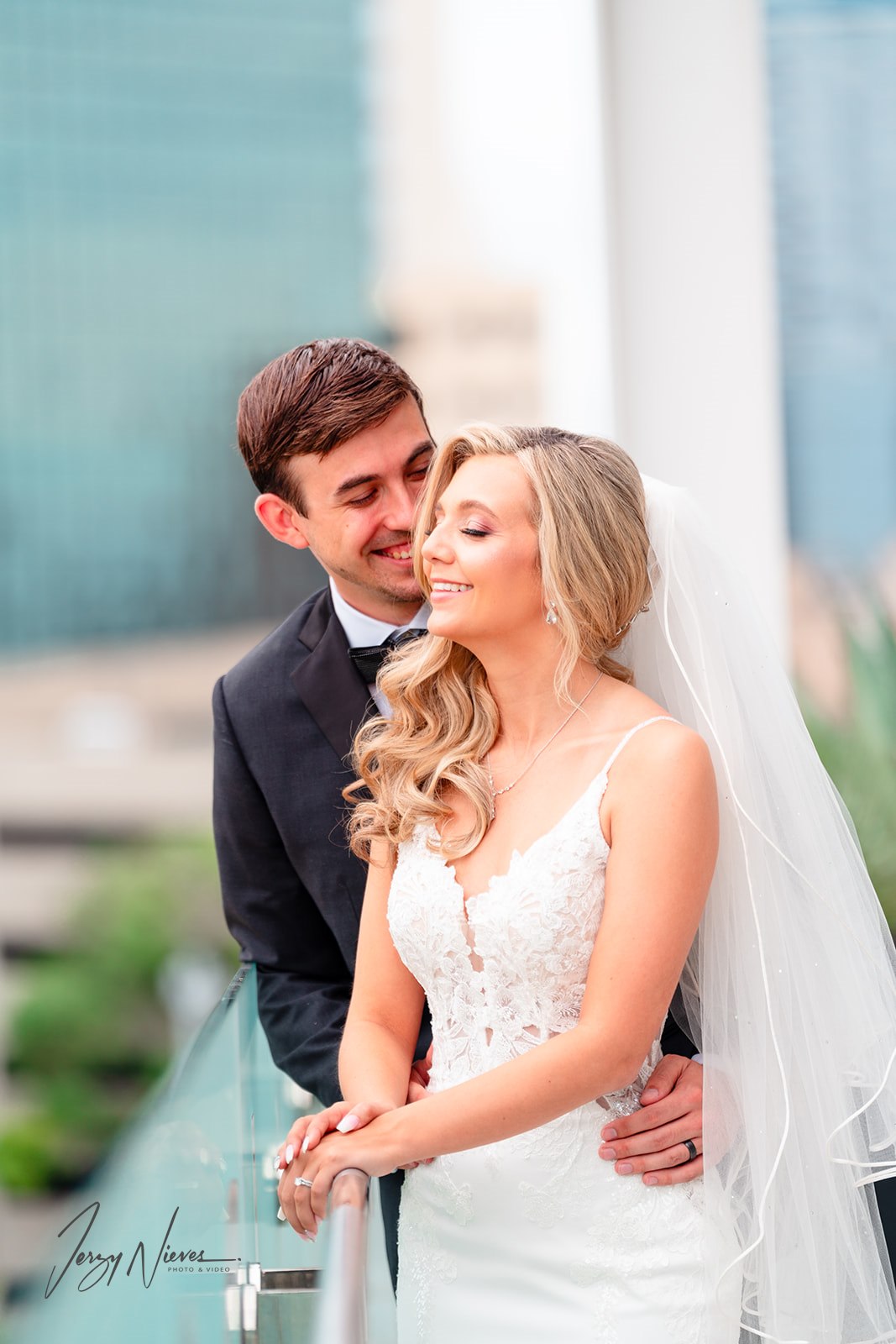 Close-up of newlyweds Brittany and Nathan embracing on the balcony of the Dr. Phillips Center for Performing Arts, focusing on their smiles and joy.