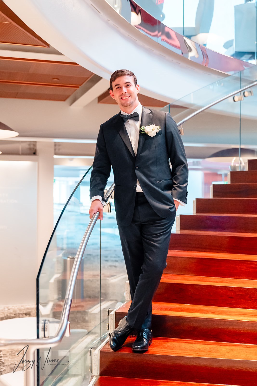 Groom posing on the stairs of the Dr. Phillips Center, showcasing his final tuxedo look before the wedding.