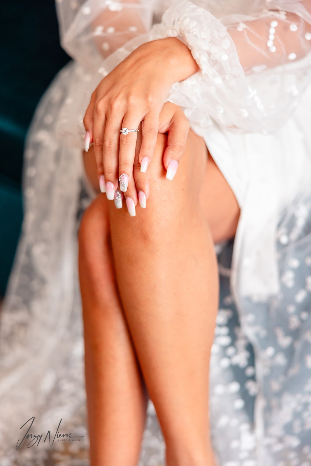 Close-up of bride Brittany’s hands resting on her knee, showing her engagement ring during pre-wedding bridal prep.