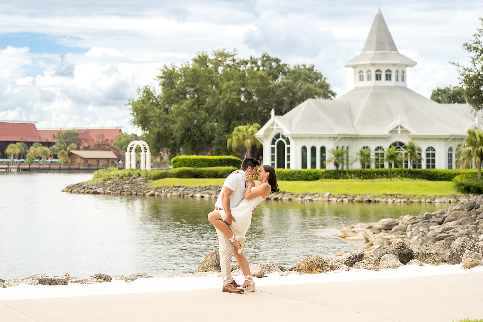 Breathtaking proposal moment: Wide shot of the same couple, capturing him as he opens the ring box against the romantic backdrop of The Oak Terrace Wedding Venue at the Hyatt Regency Grand Cypress in Orlando FL.